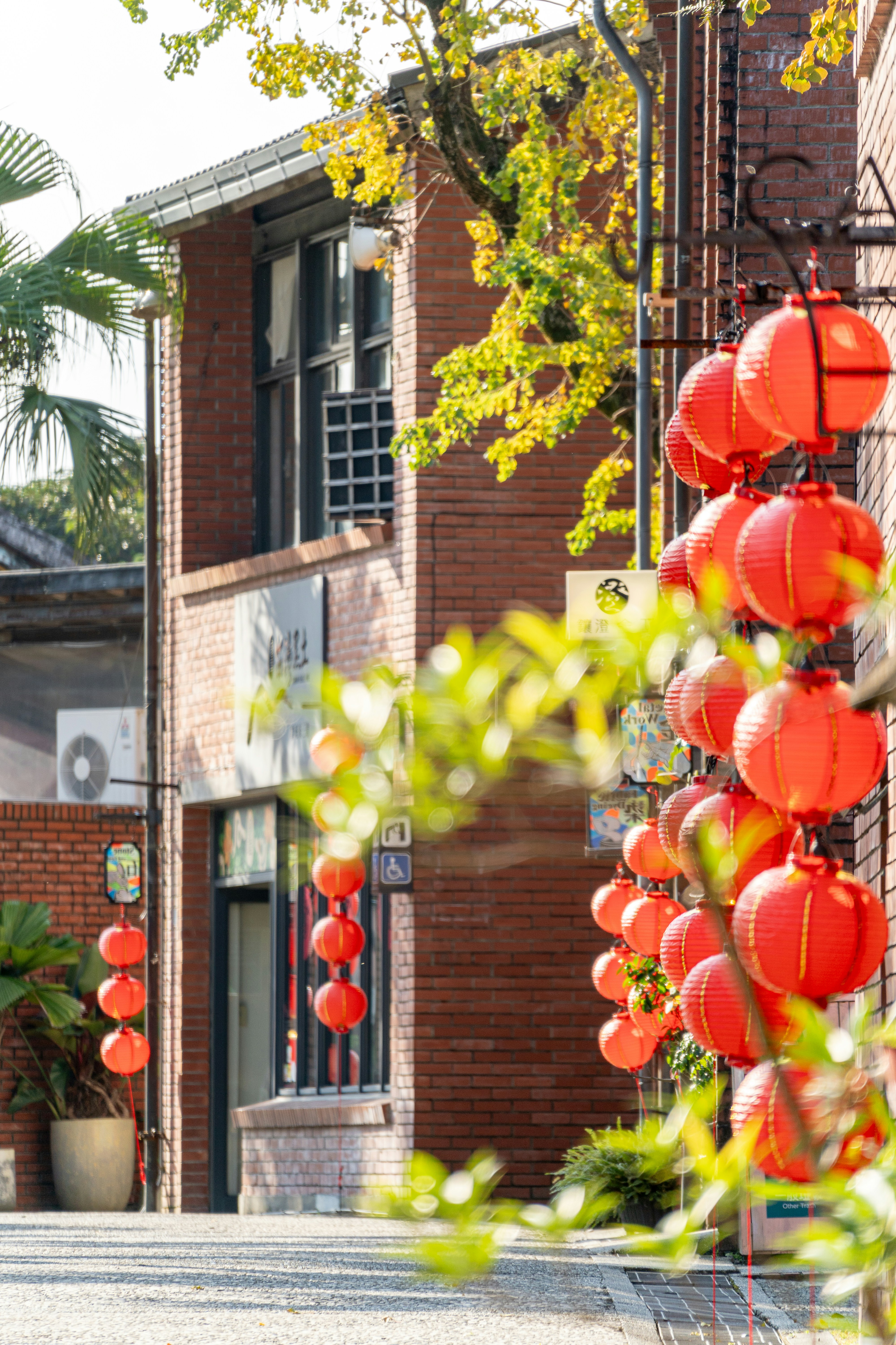 Red lanterns hang outside a brick building.