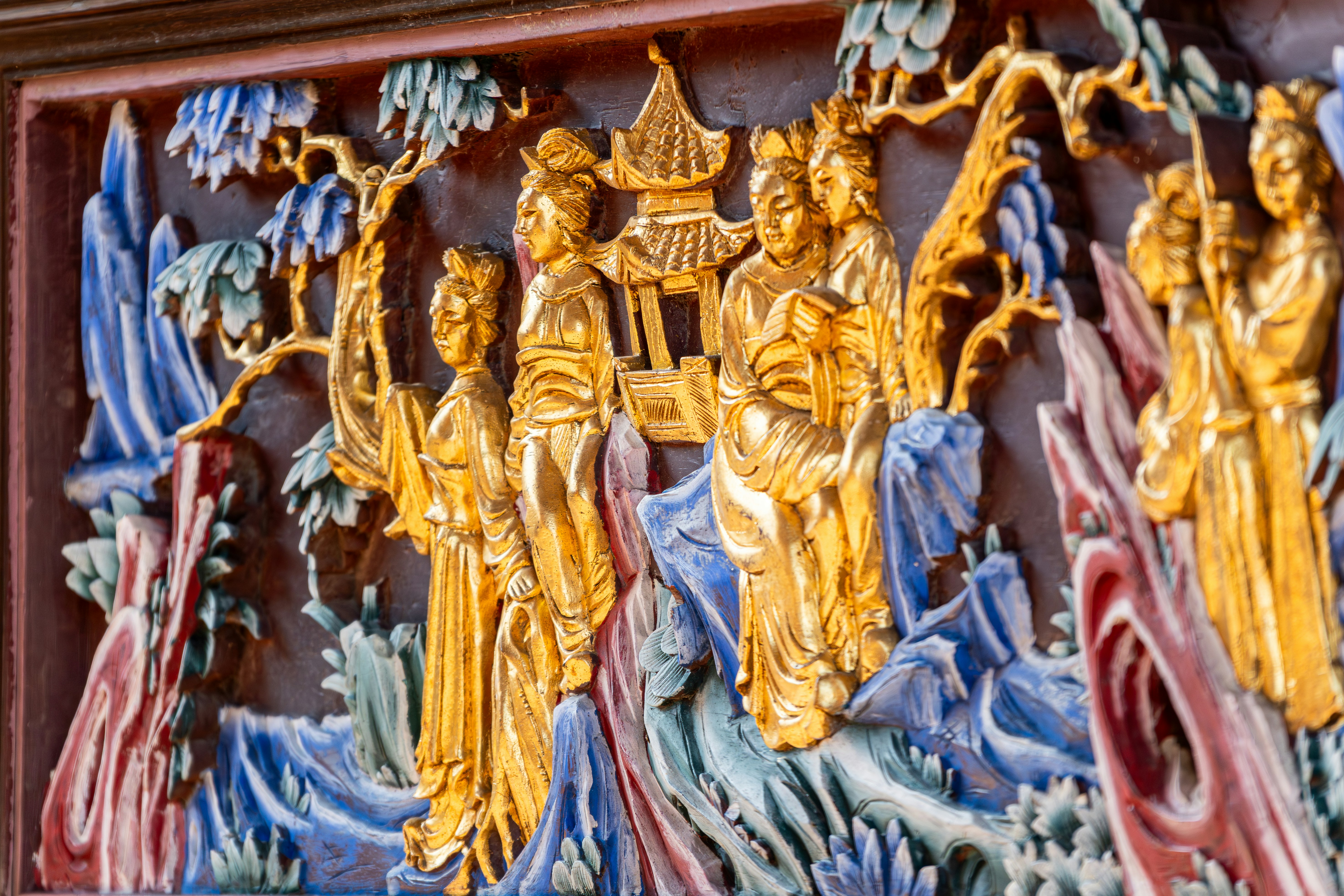 Ornate golden relief carving of figures and nature