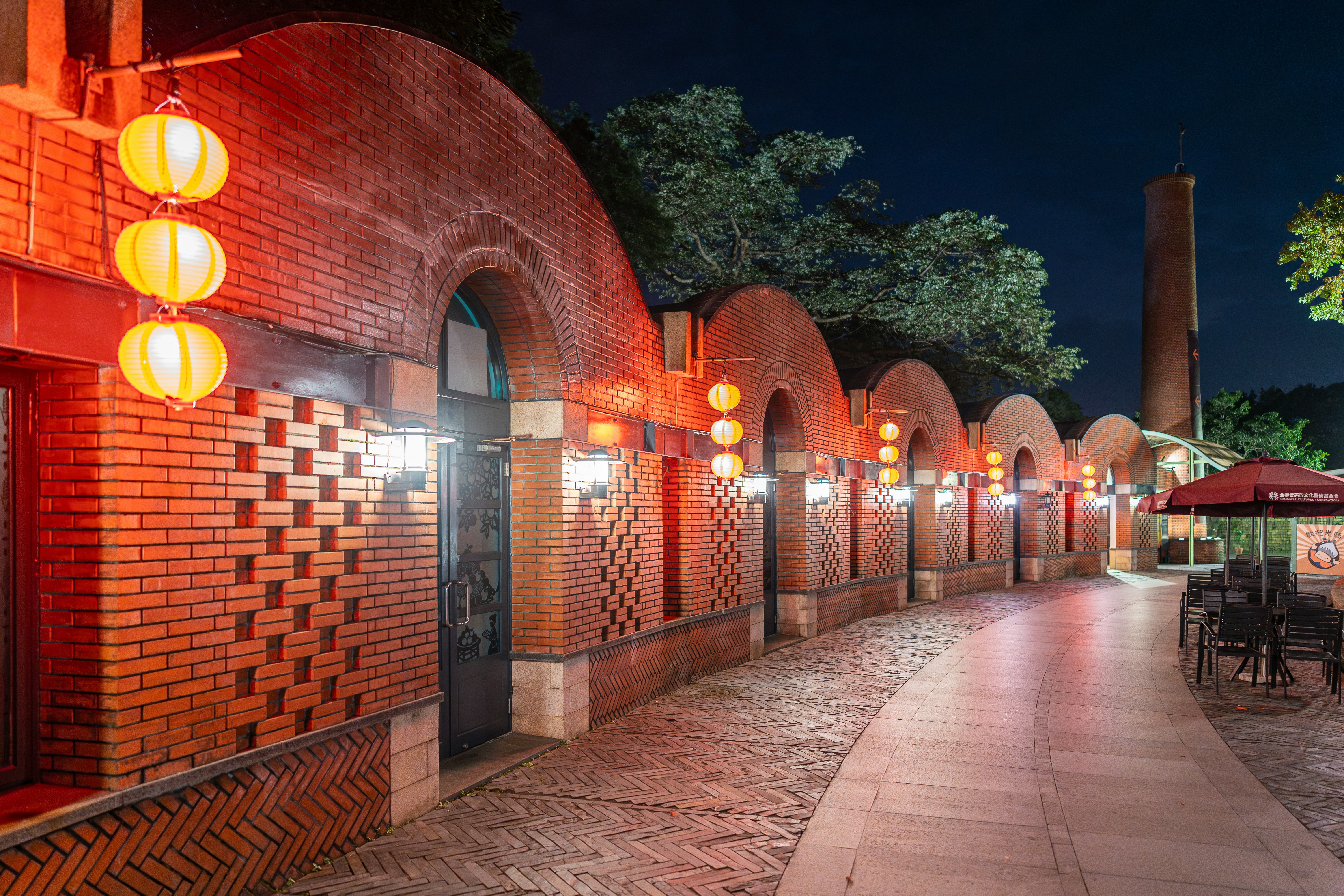 Brick building with arched windows and lanterns at night