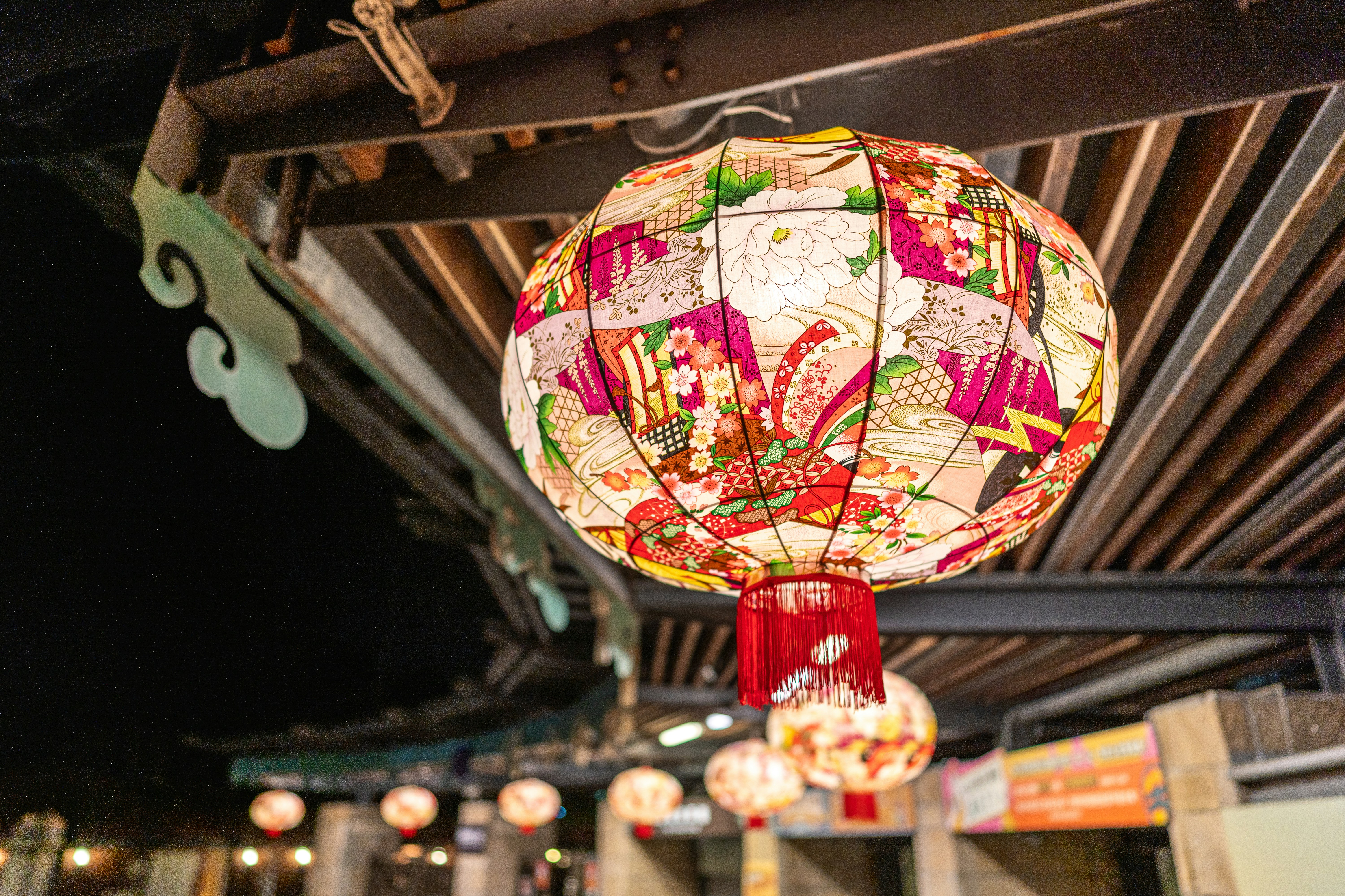 Ornate lantern illuminated at night with others in the background