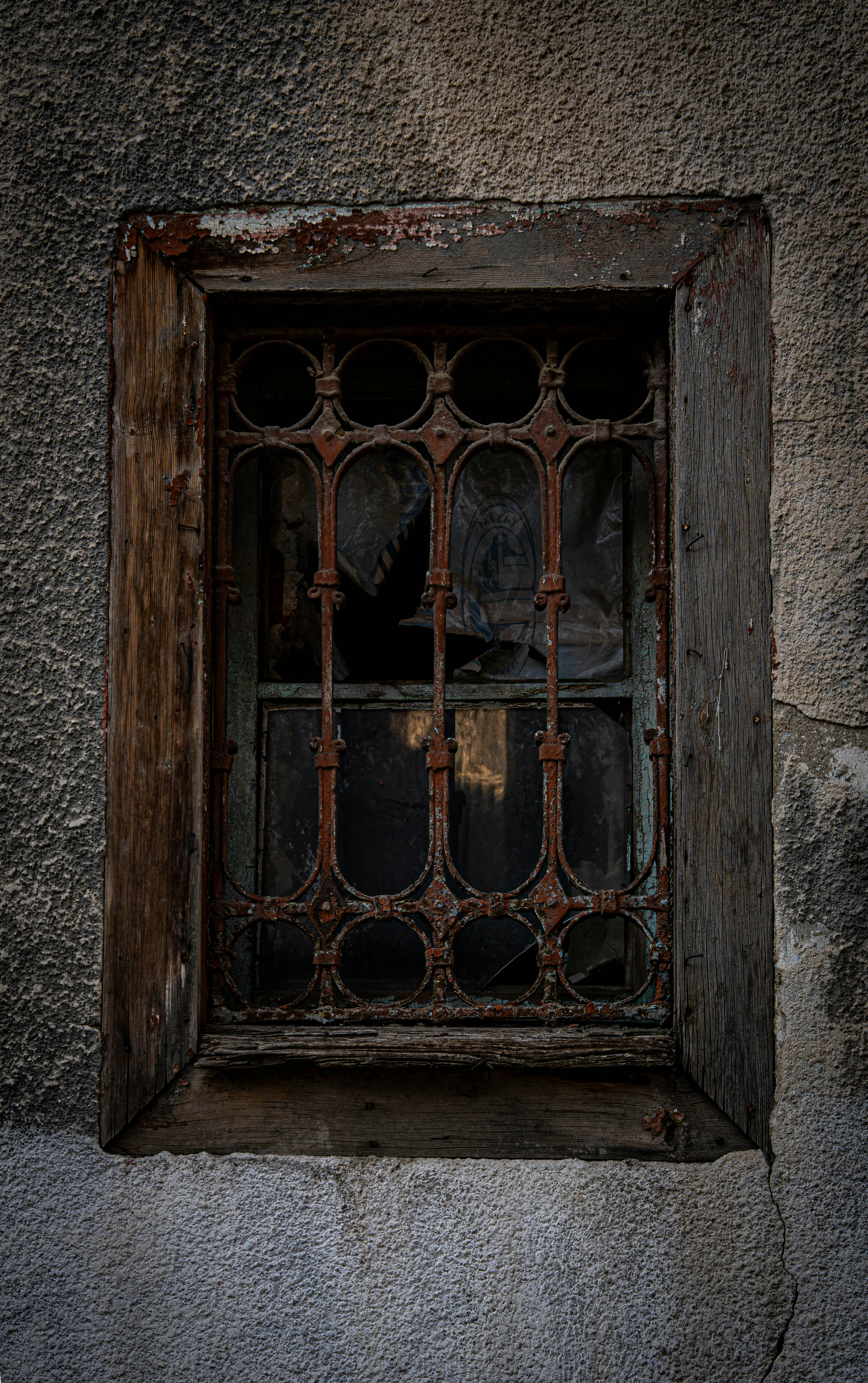 Old weathered window with rusty iron bars
