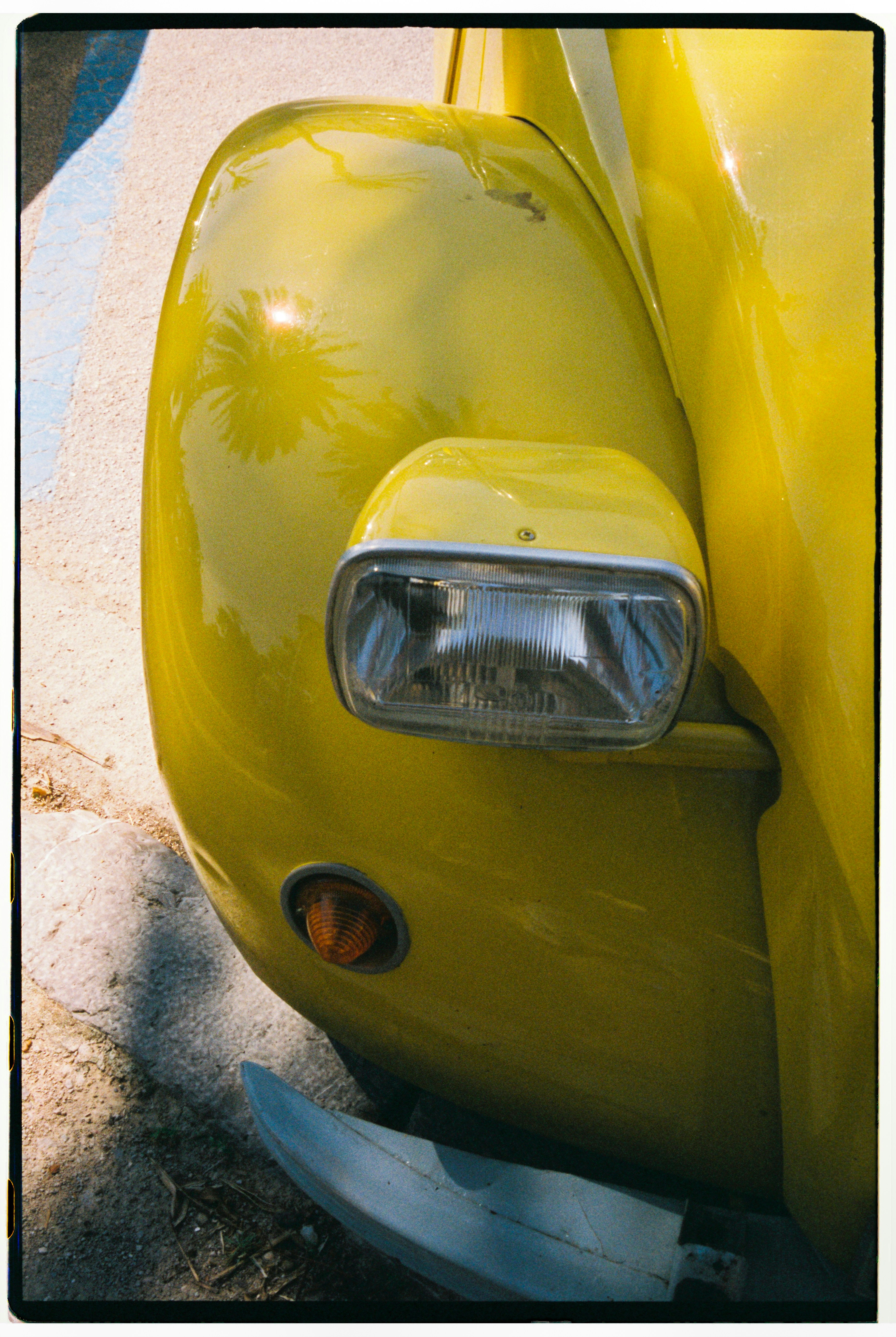 Close-up of a shiny yellow vintage car headlight.