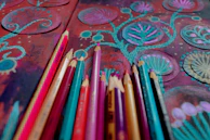 Colored pencils arranged on a textured, artistic background.