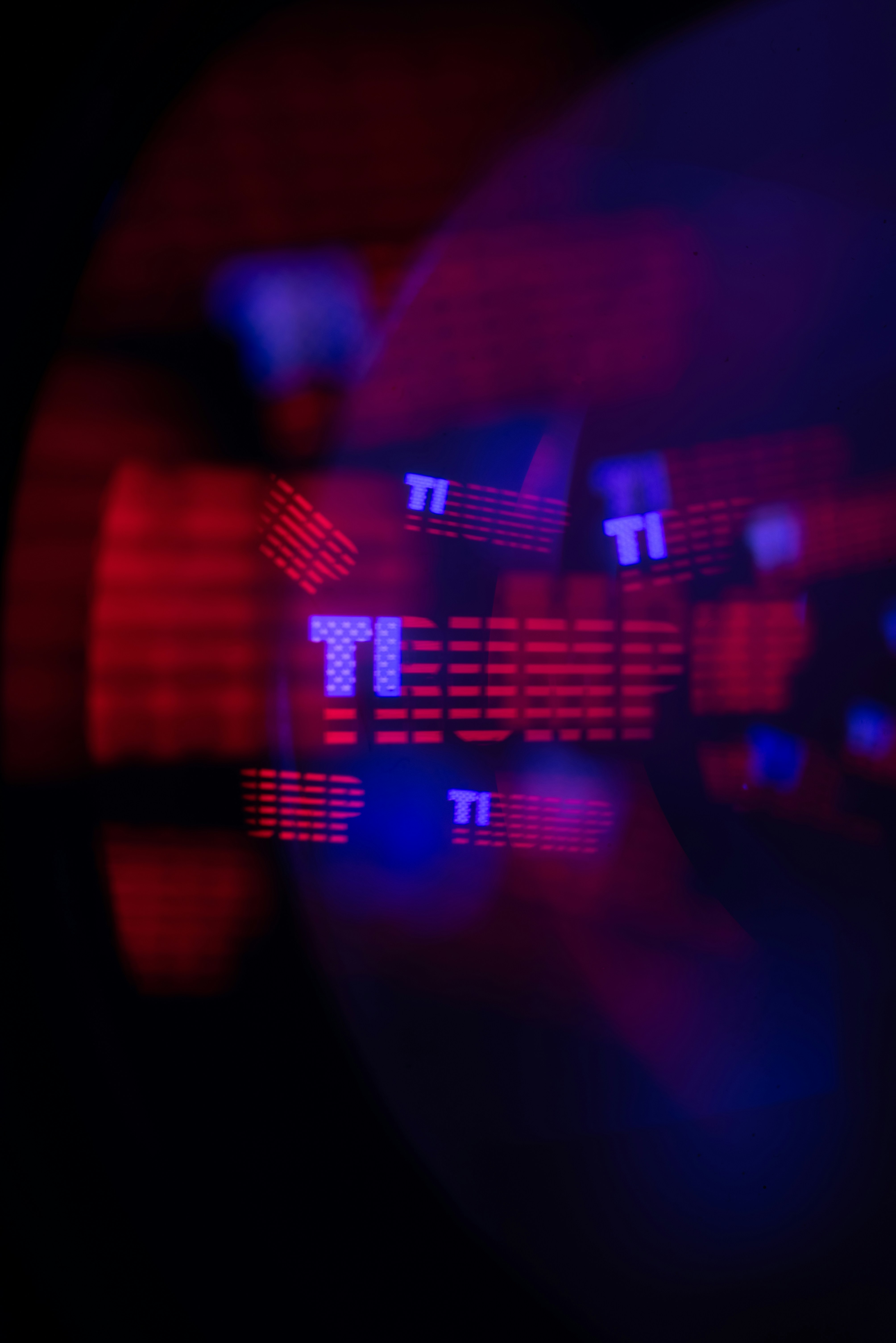 Blurred red and blue lights with the letters ti visible