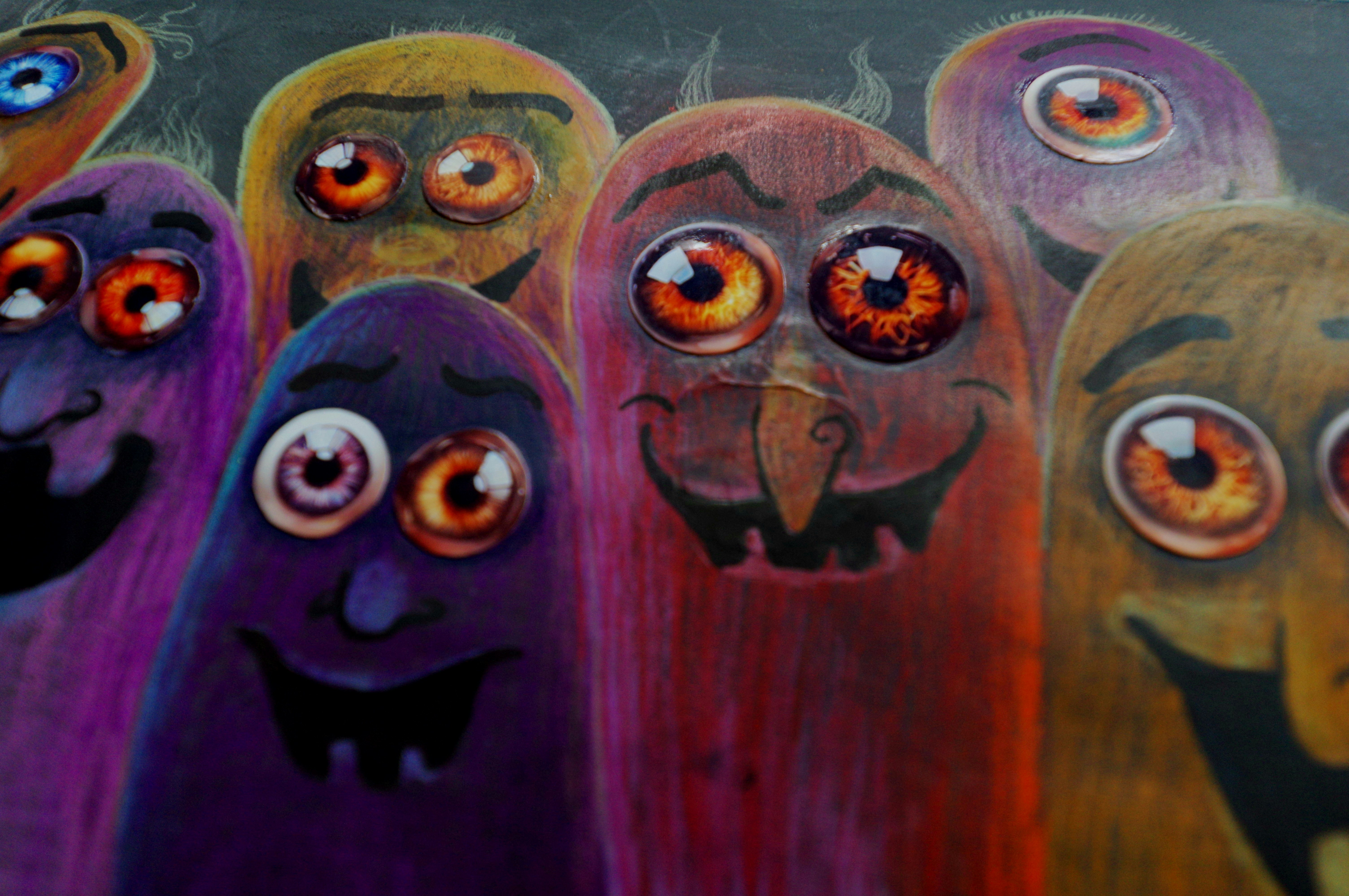 A group of colorful, cartoonish monsters with large eyes.