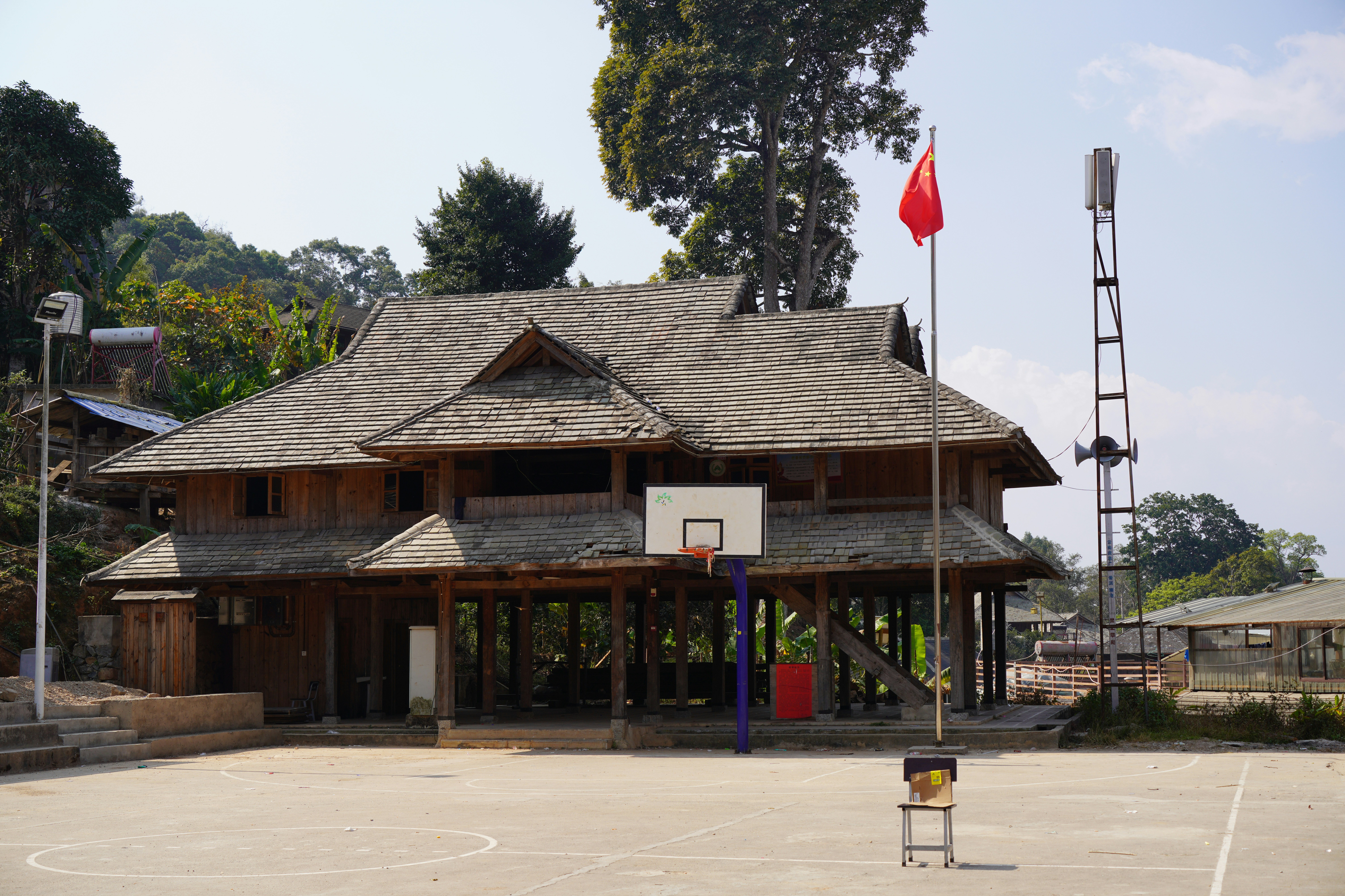 Wooden building with basketball court and flag