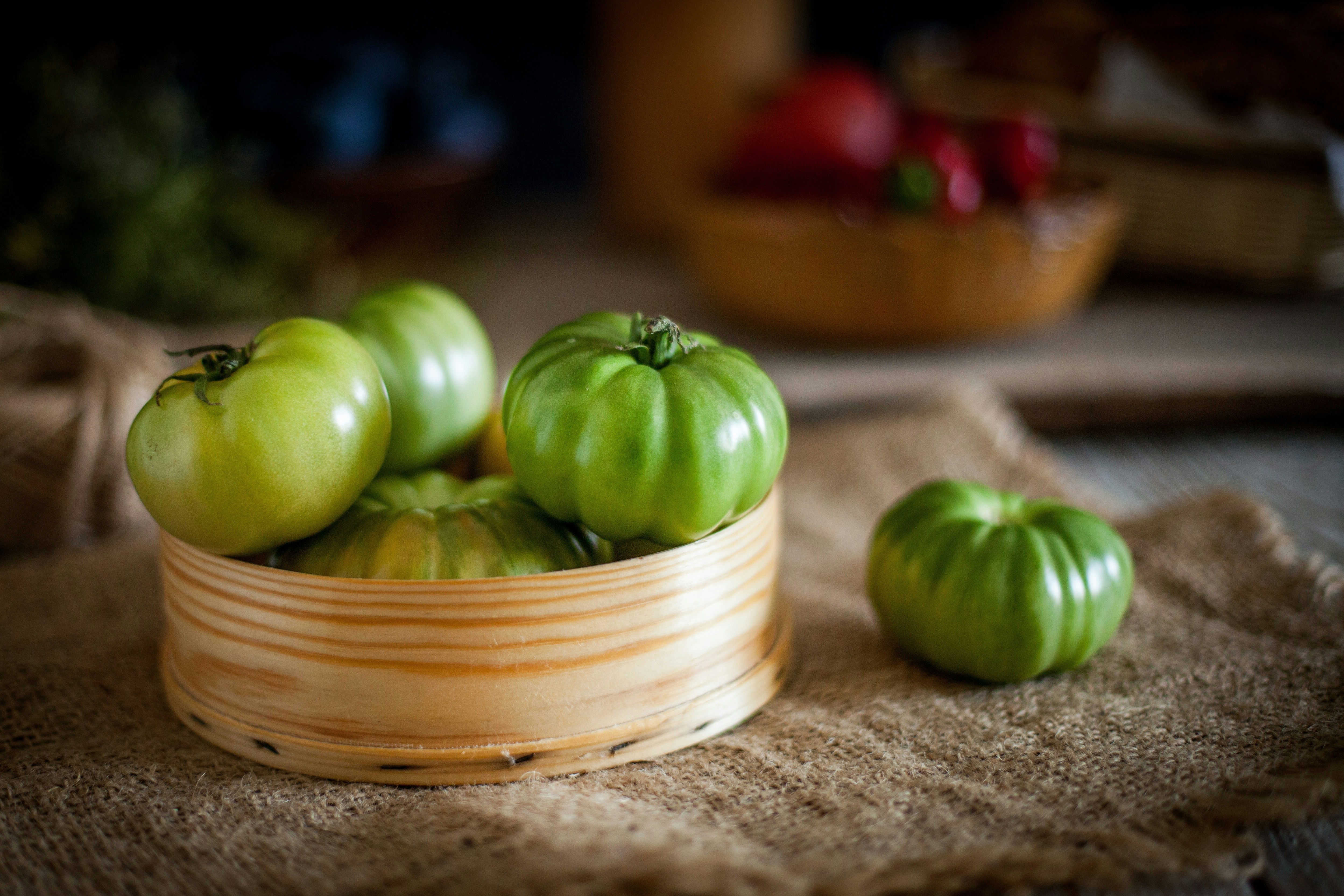 Mehrere grüne Tomaten in einer Holzschüssel