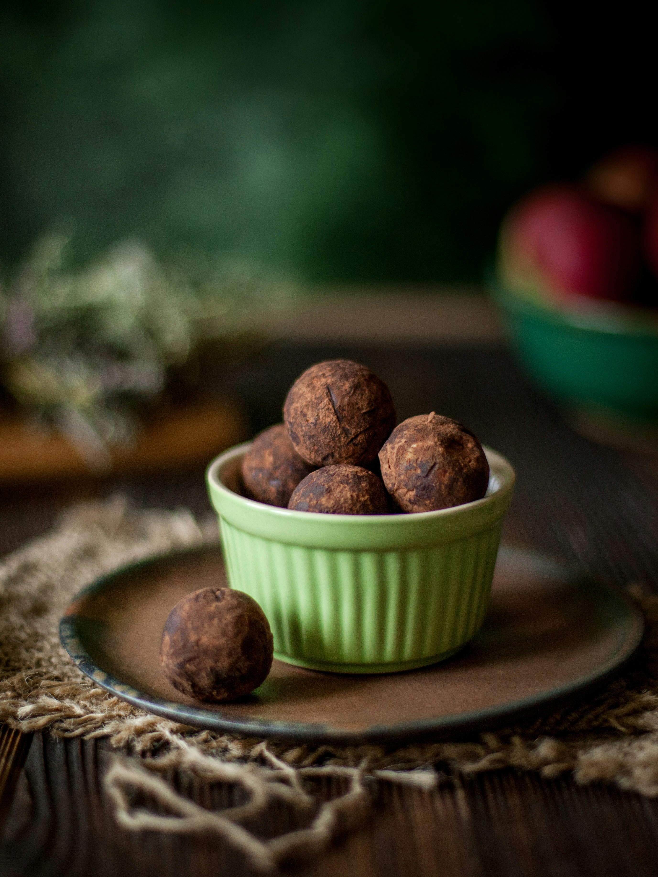 Schokoladentrüffel in einer grünen Schüssel auf einem rustikalen Tisch.
