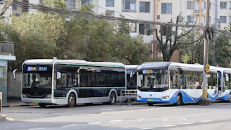 Two modern buses parked at a station.