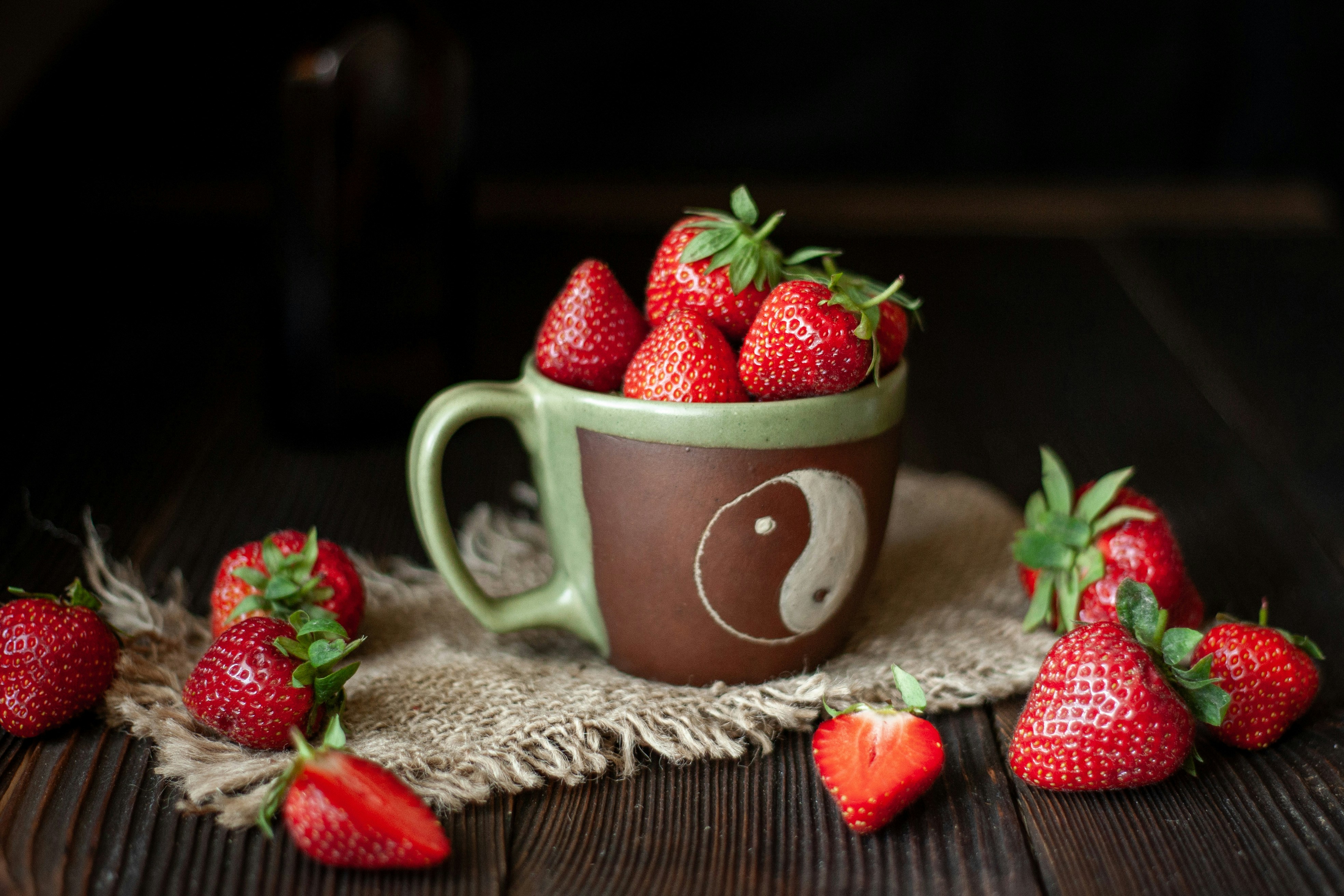 Frische Erdbeeren füllen eine Tasse mit dem Yin-Yang-Symbol.