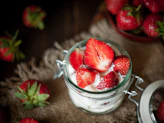 Fresh strawberries with cream in a glass jar
