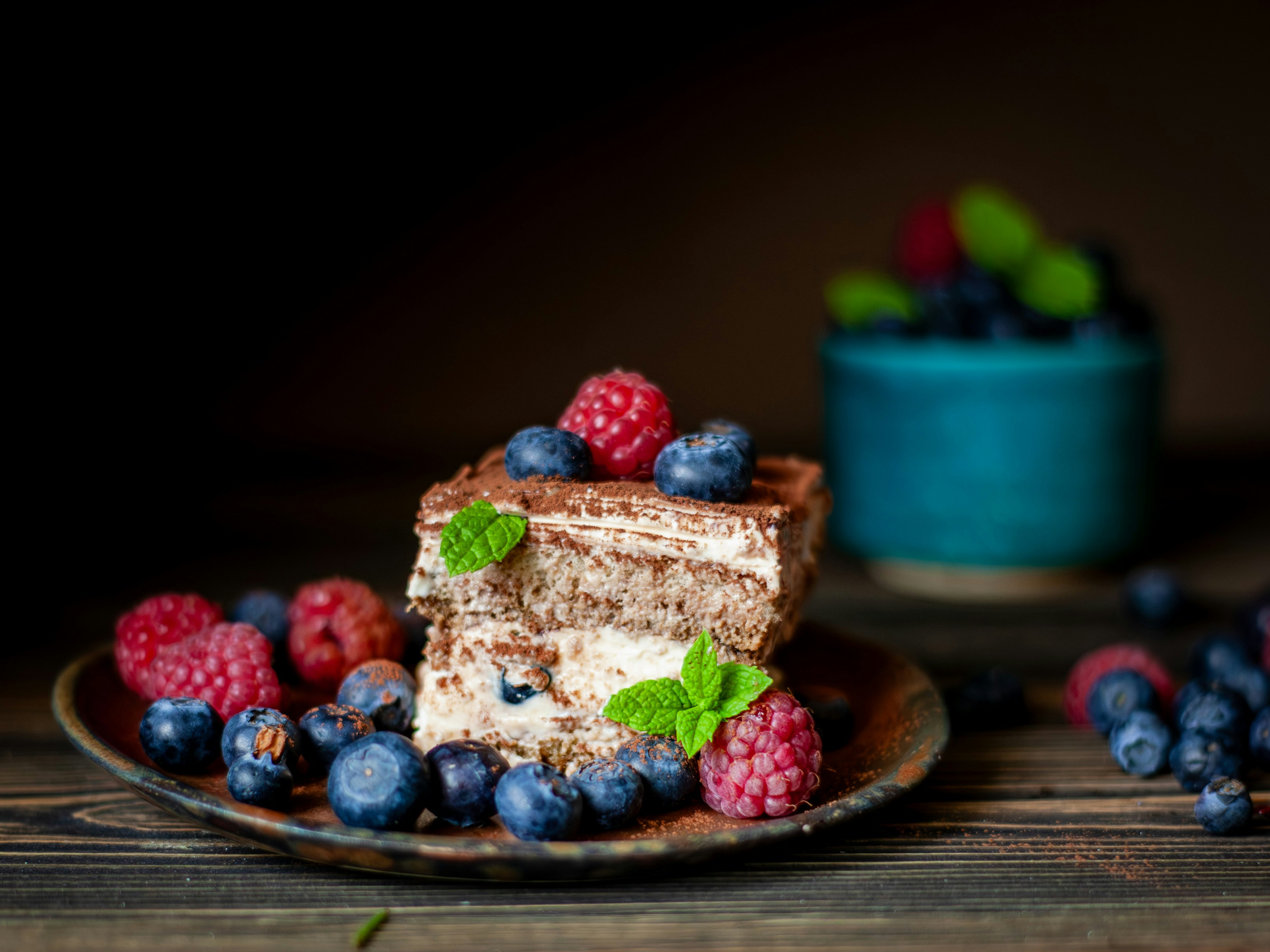 Ein Stück Schokoladenkuchen, garniert mit Beeren und Minze
