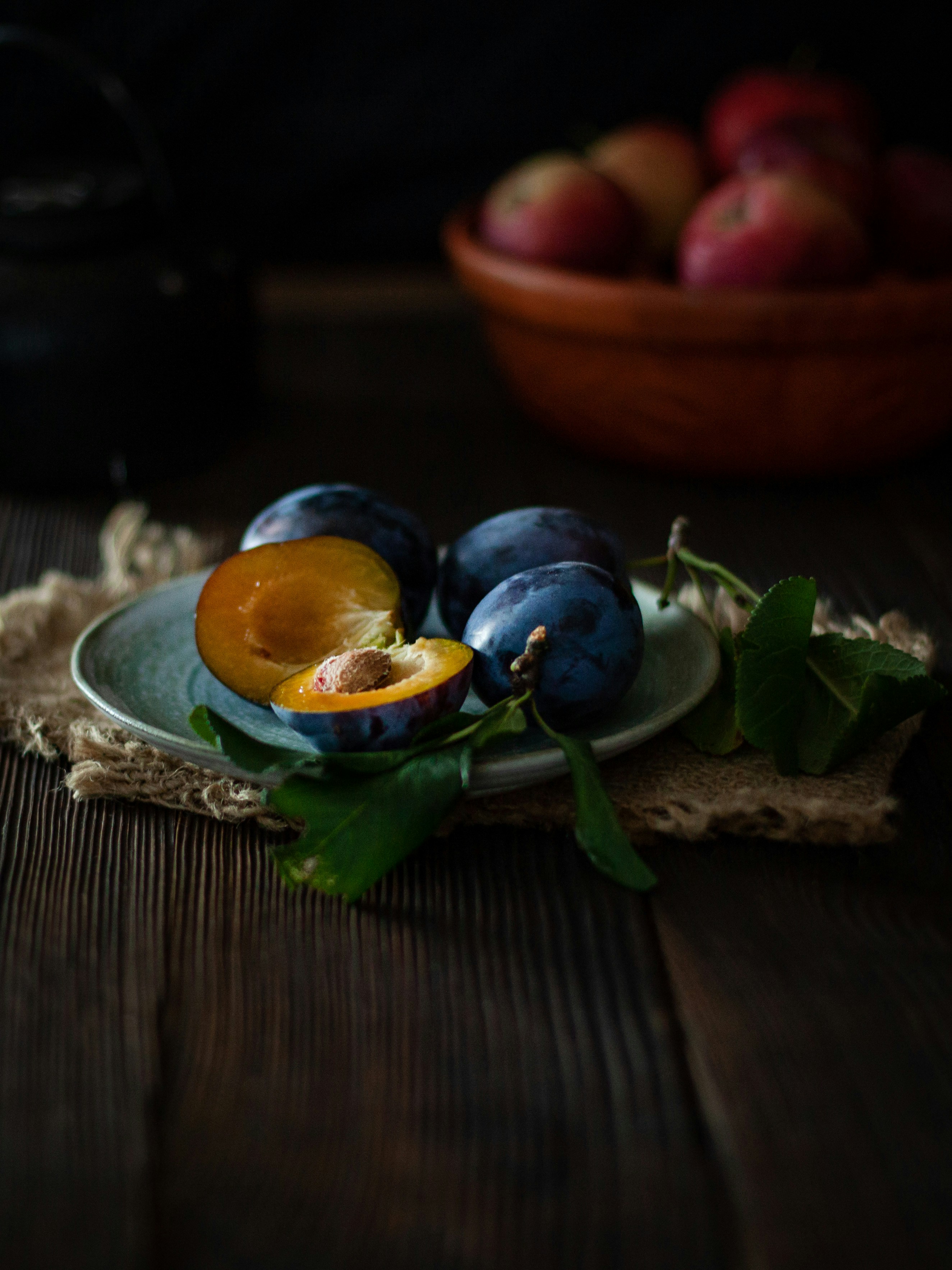 Frische Pflaumen auf einem Teller mit Blättern
