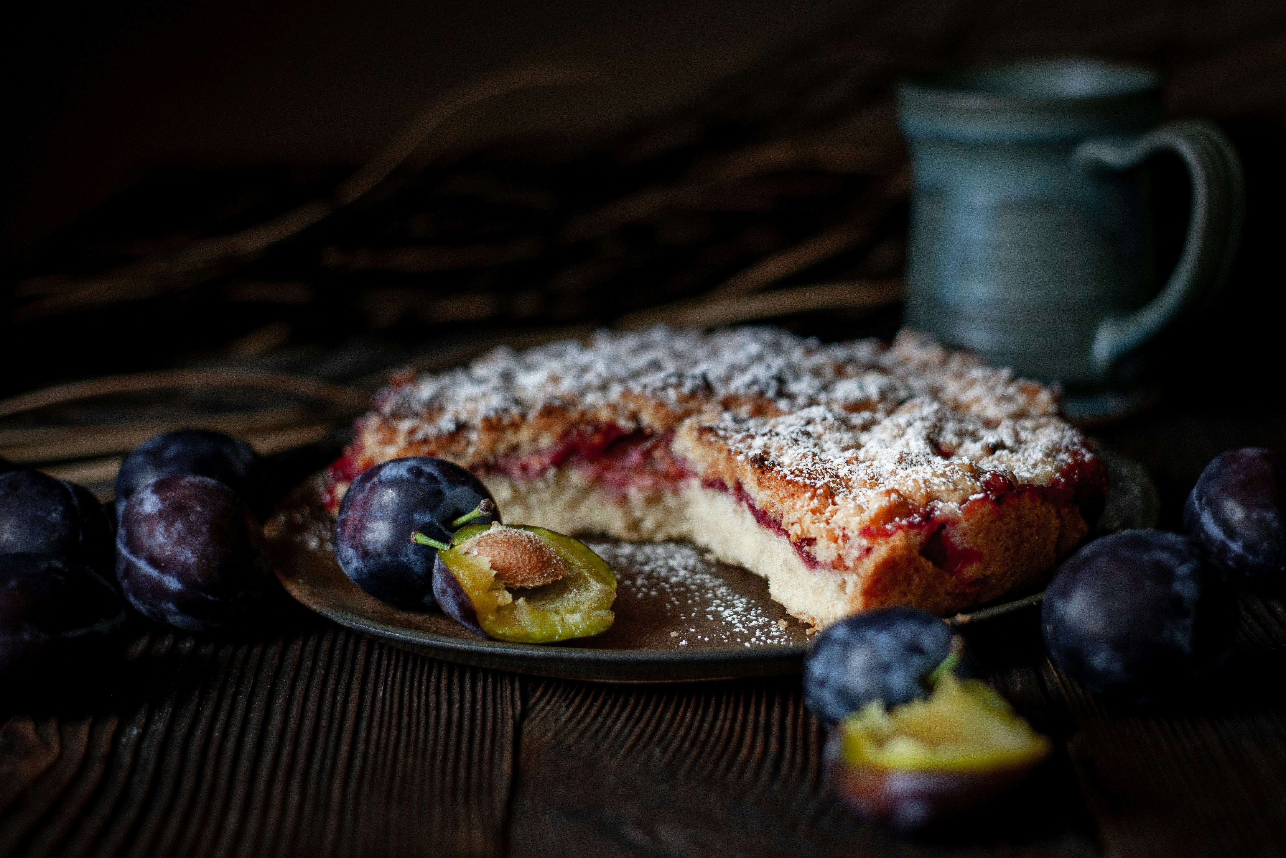 Pflaumenkuchen, bestäubt mit Puderzucker und frischen Pflaumen, bestäubt