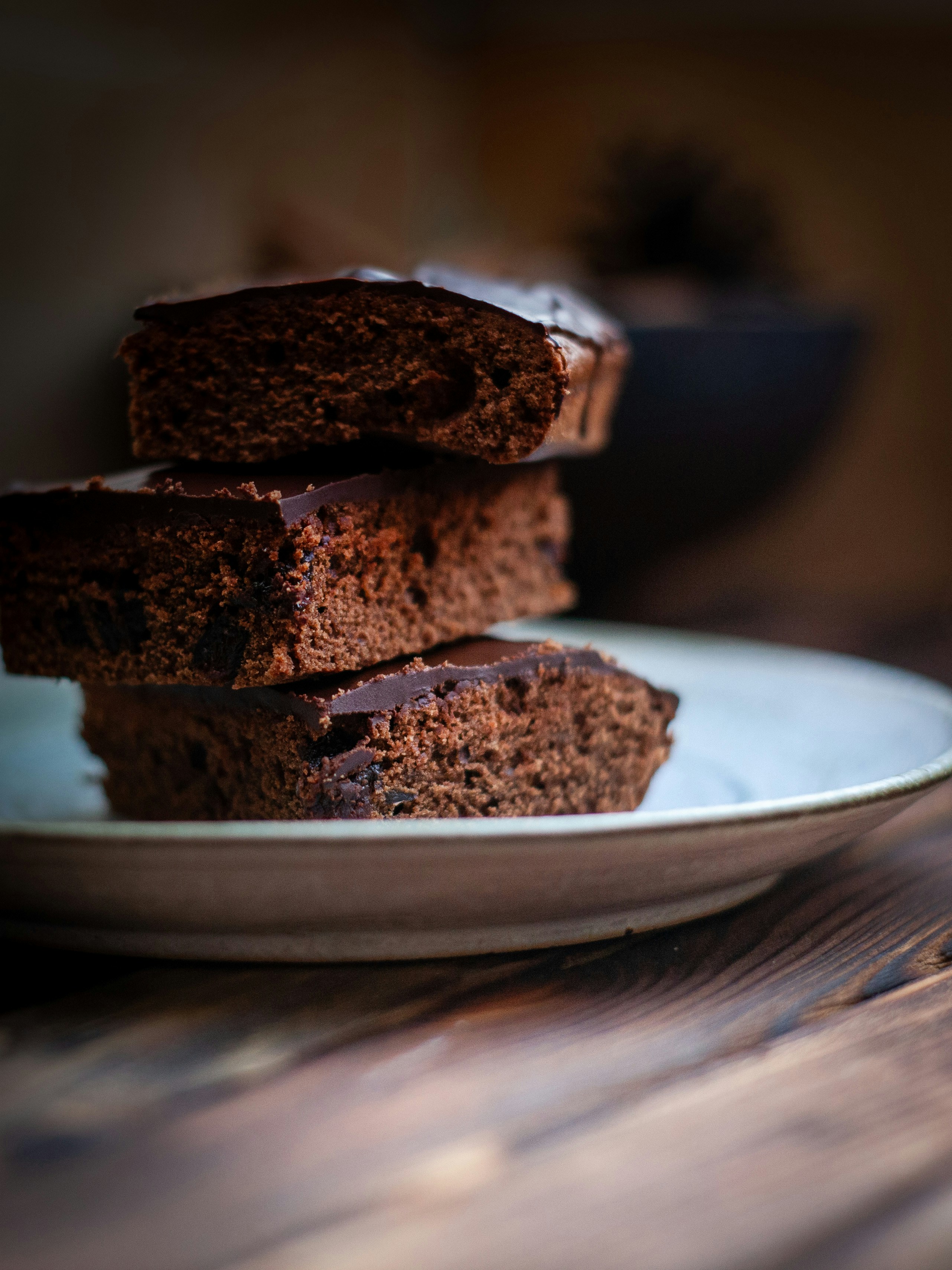 Stapel von drei Schokoladenbrownies auf einem Teller.