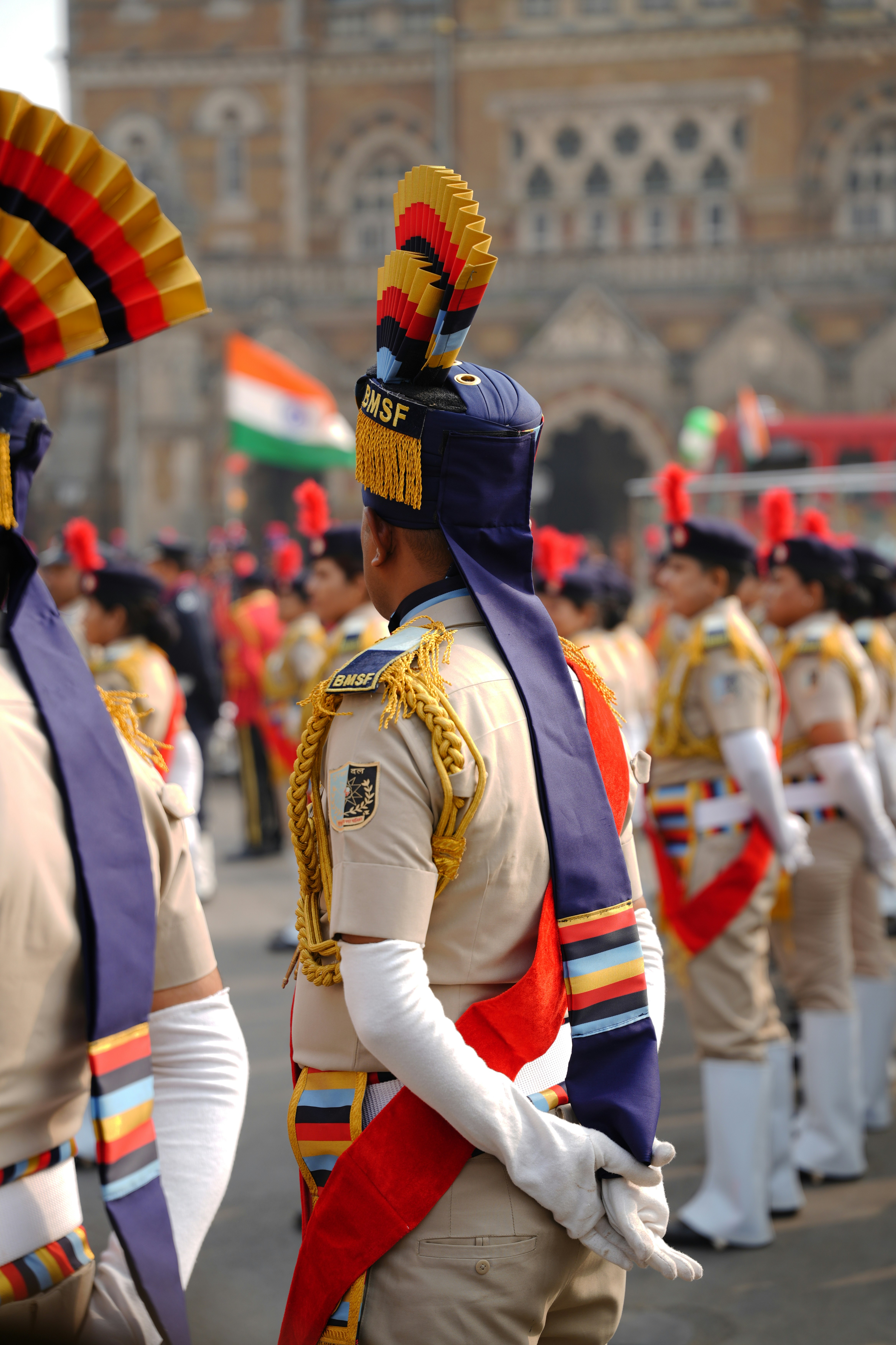 Soldiers in uniform with colorful hats at a parade.