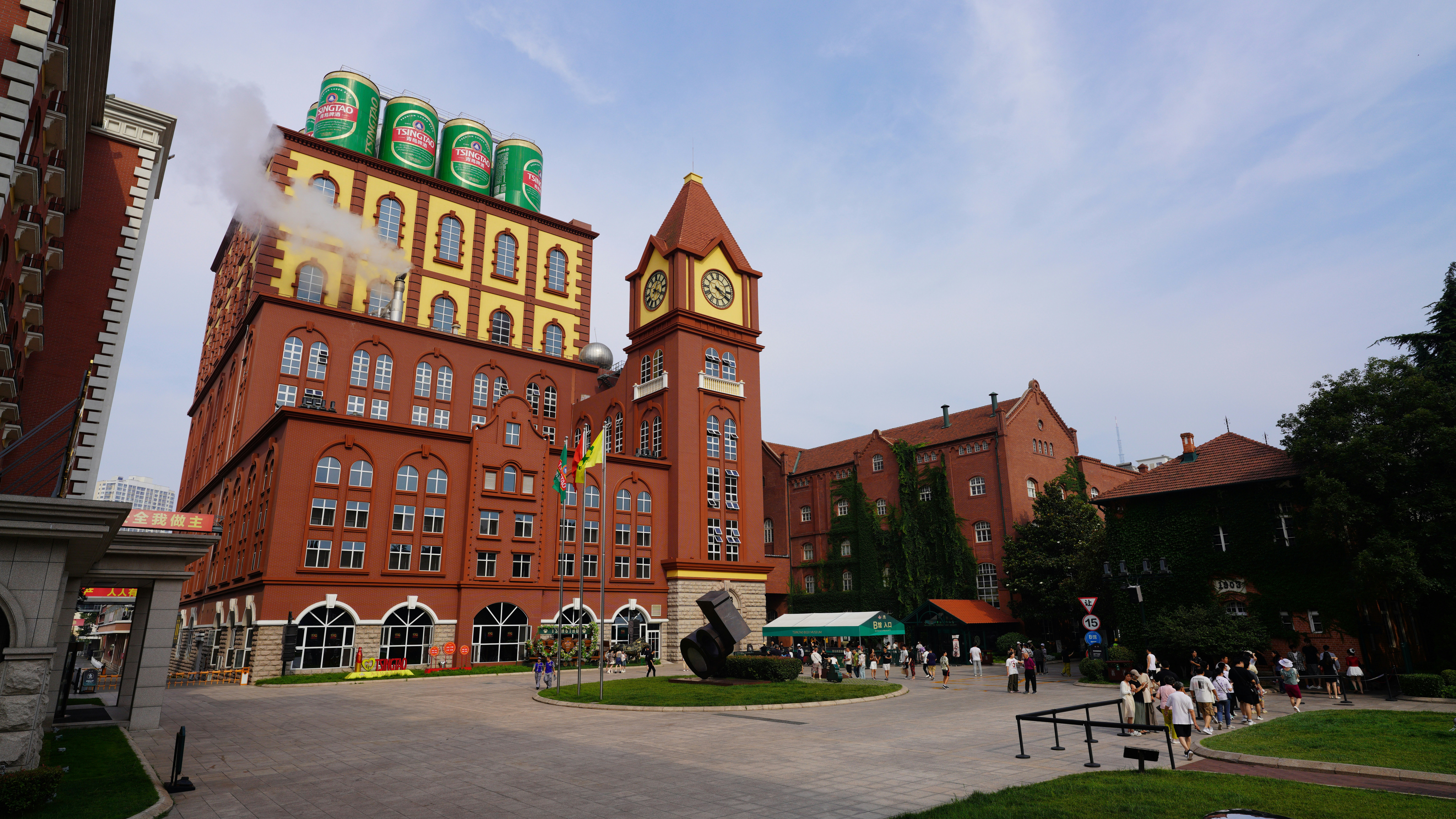 Brick building with clock tower and green cans on roof.