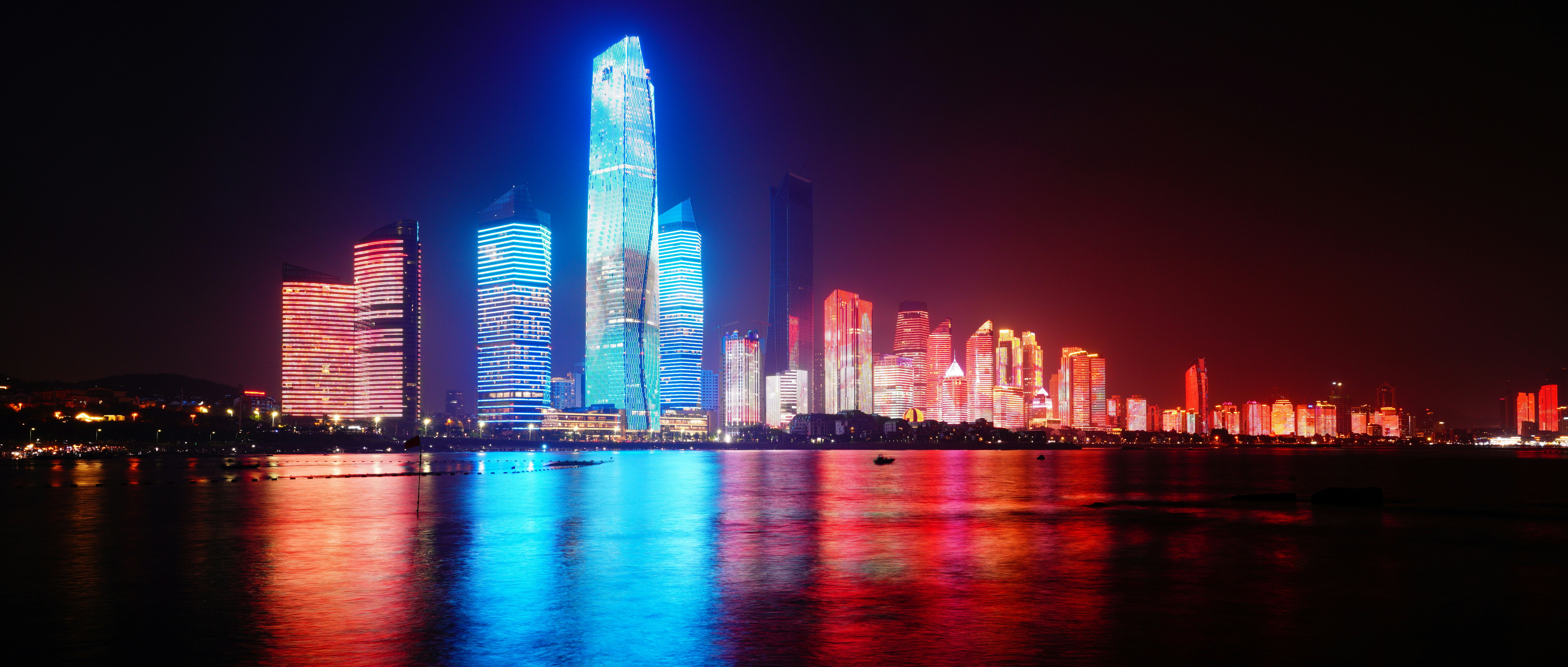 Colorful illuminated skyscrapers reflected in the water at night