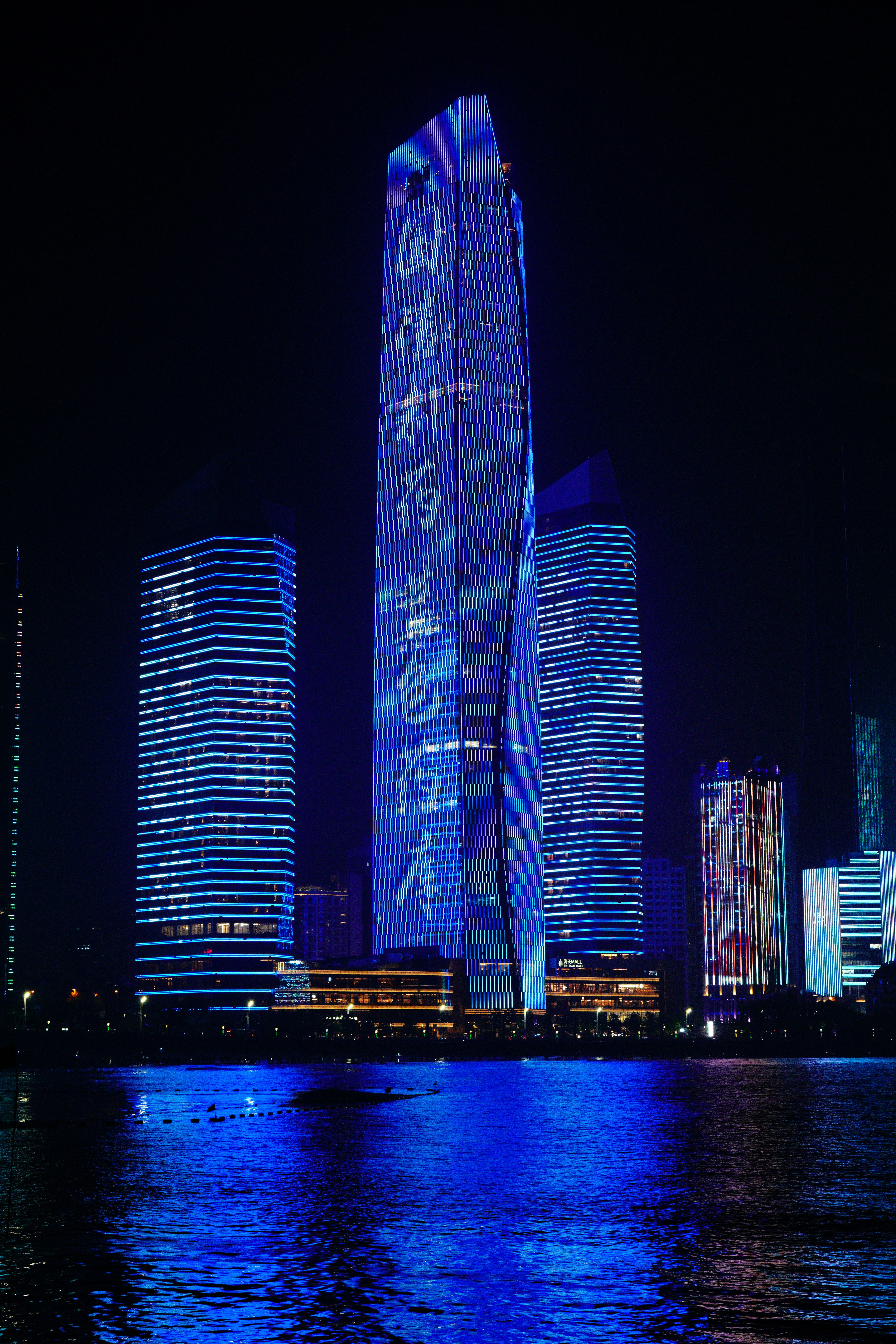 Modern skyscrapers illuminated at night with blue lights. photo – Free ...