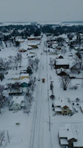 Snowy street in a small town with a snow plow.