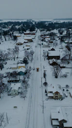Snowy street in a small town with a snow plow.