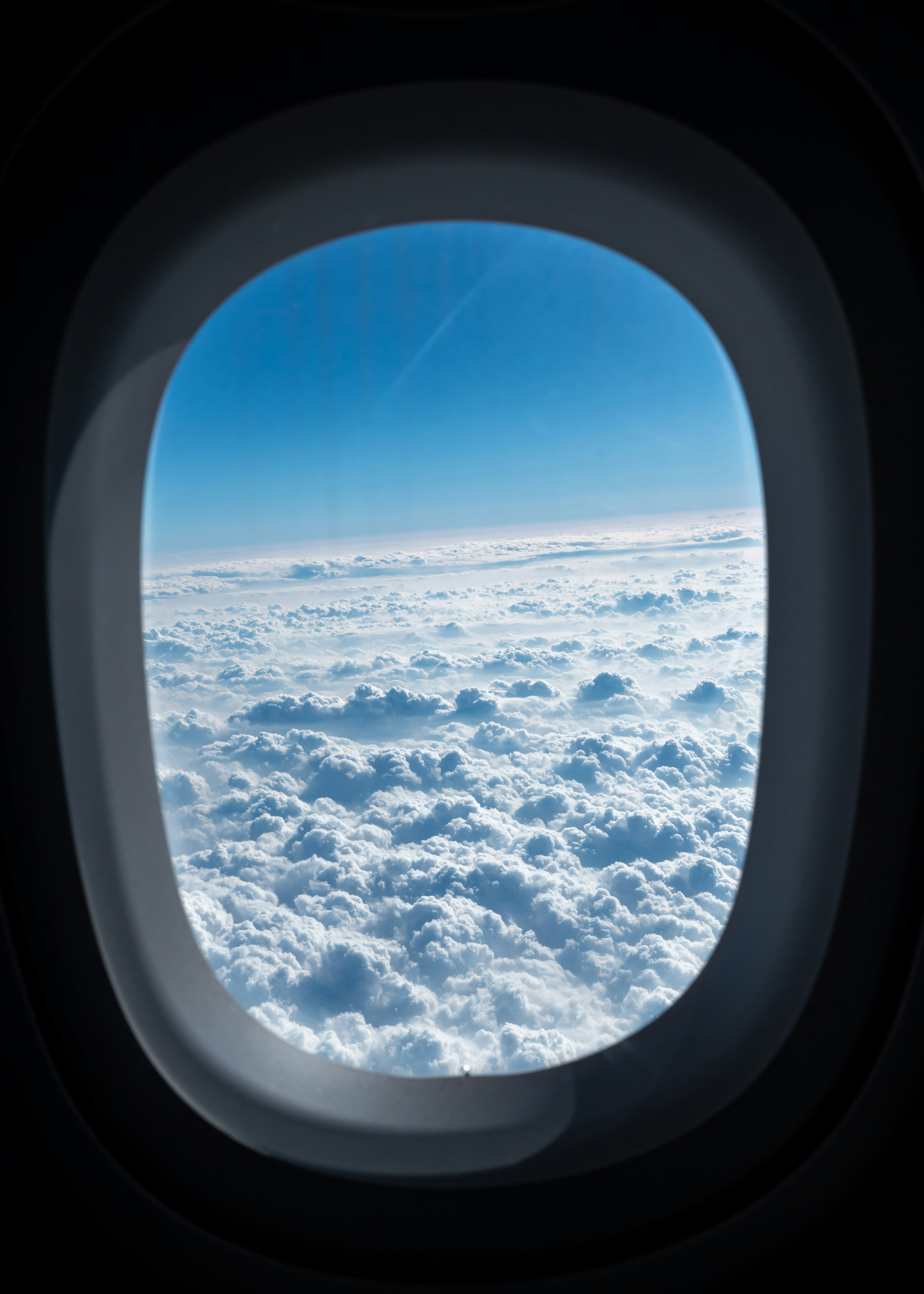 View of clouds and blue sky from airplane window