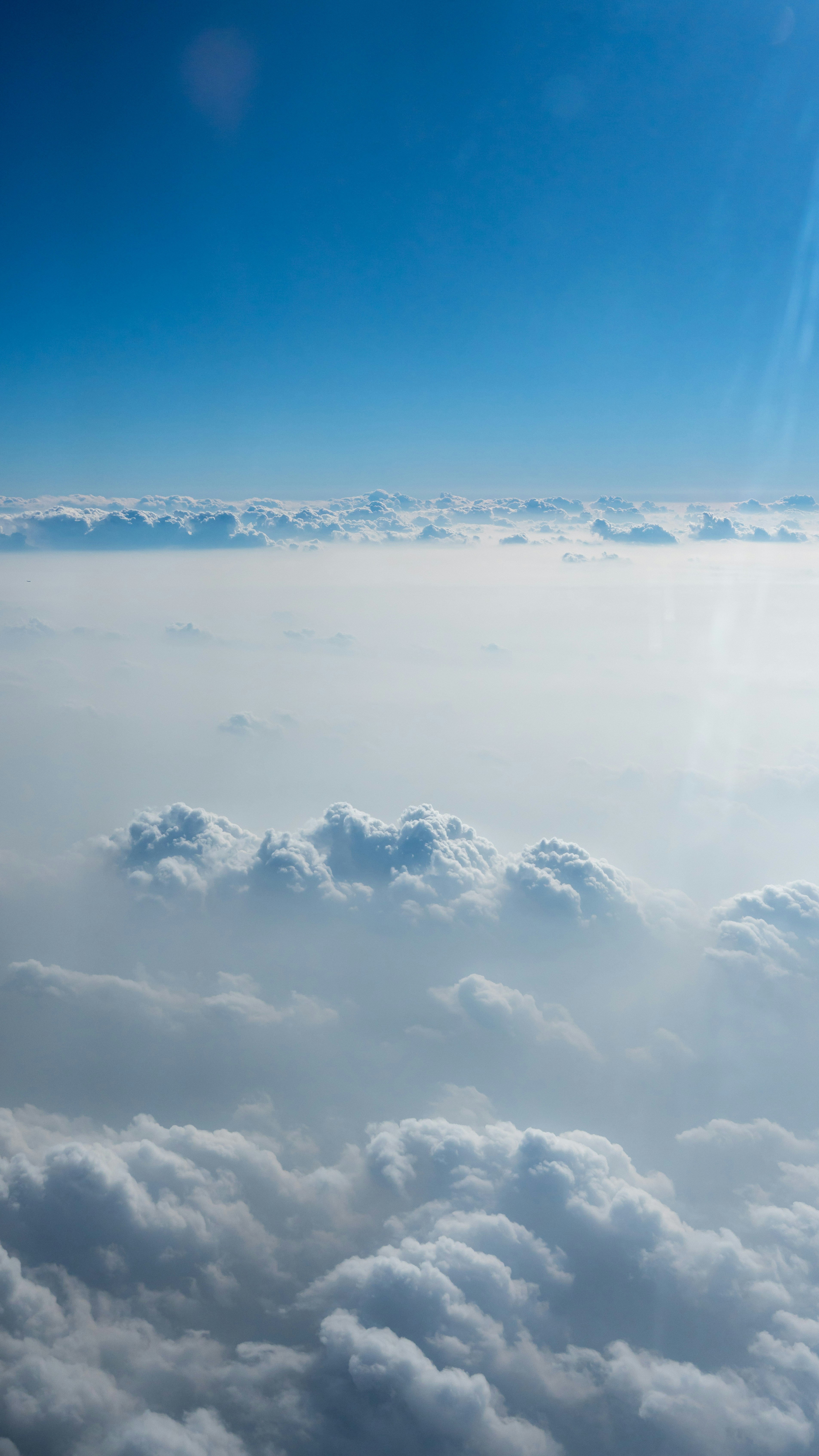 Fluffy white clouds under a clear blue sky.