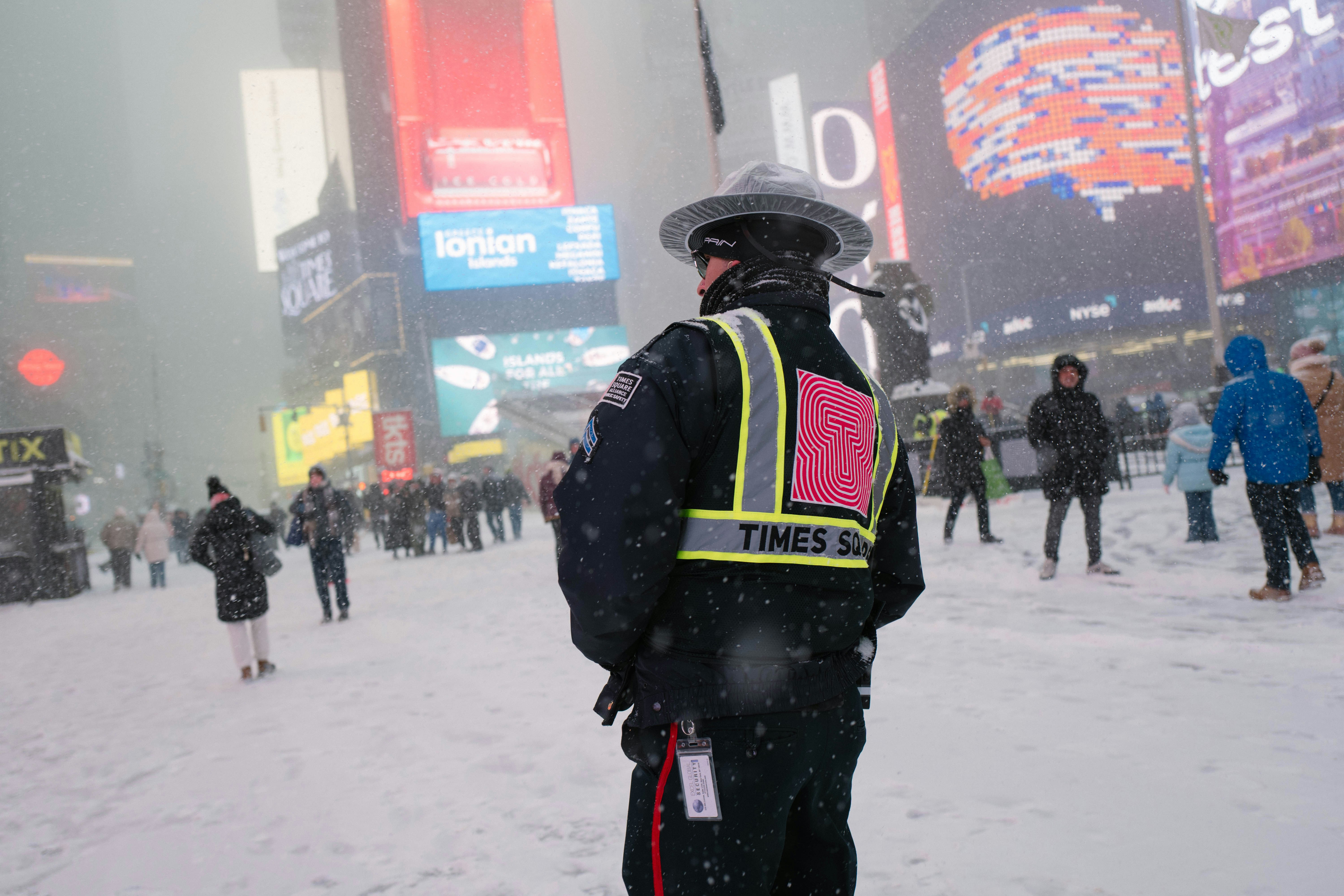 Times square officer in snowstorm with blurred billboards