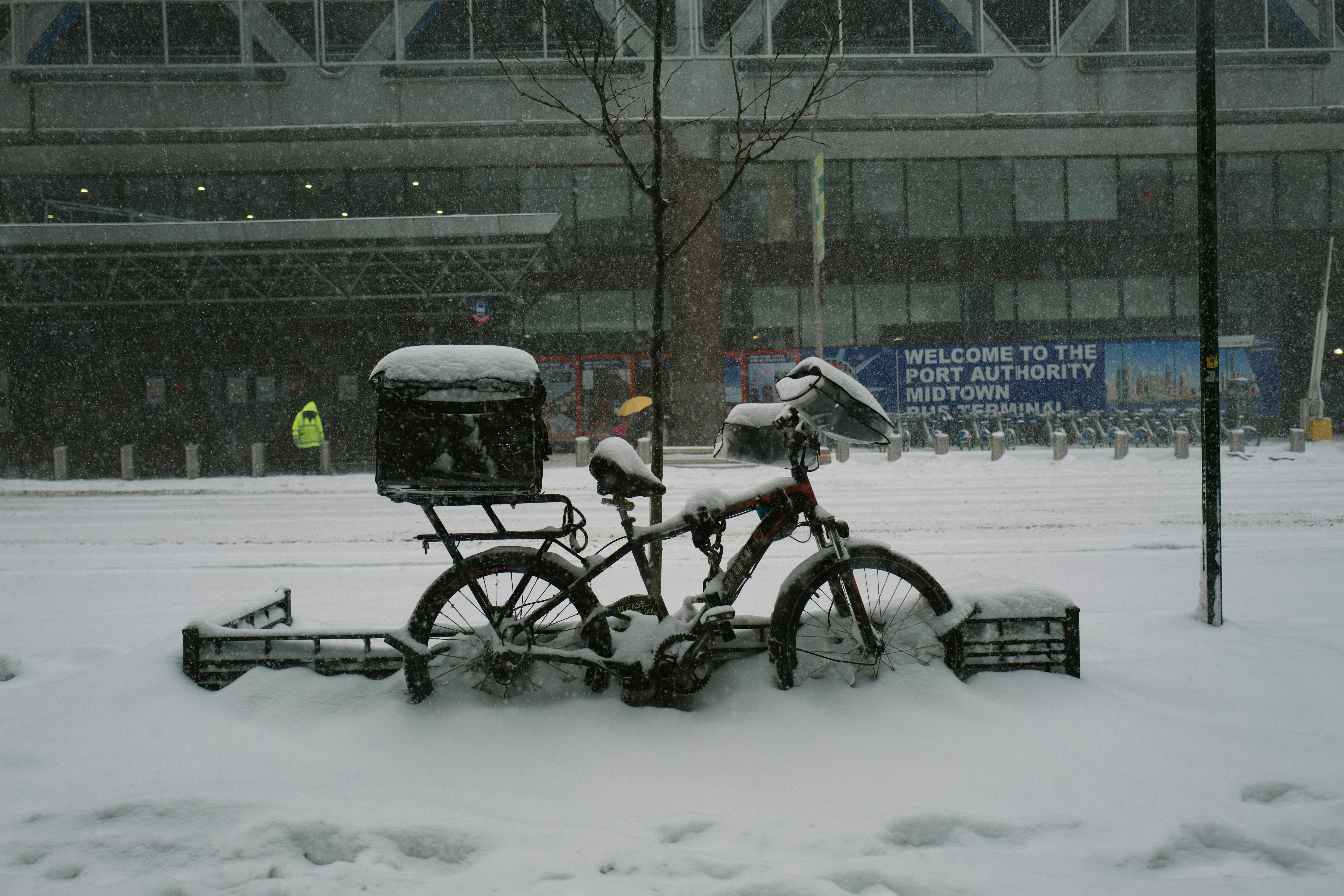 Bicycle with snow plow attachment covered in snow.