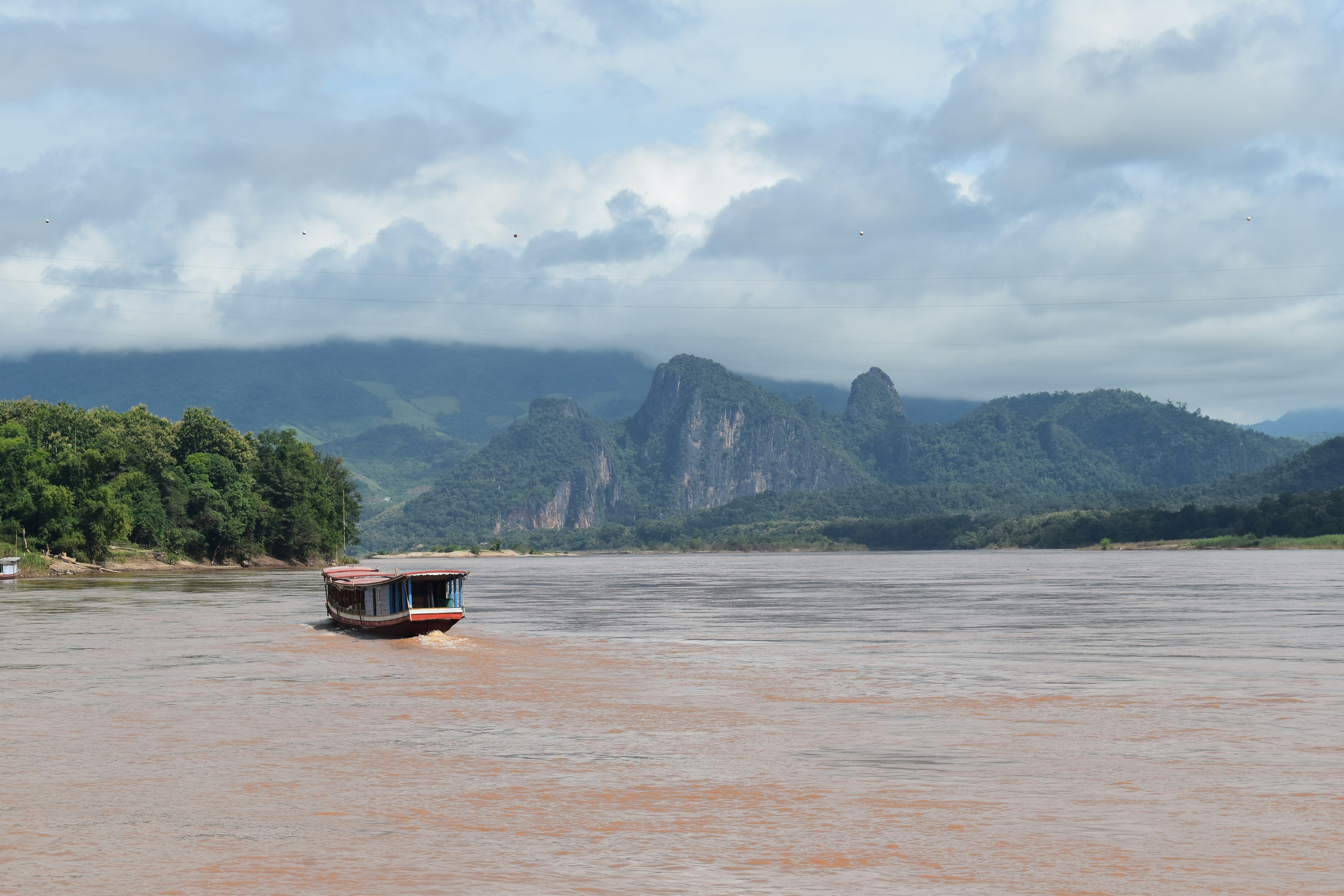 A river traverses along the Mekong river, near Luang Prabang, Laos. Pha An in the background.