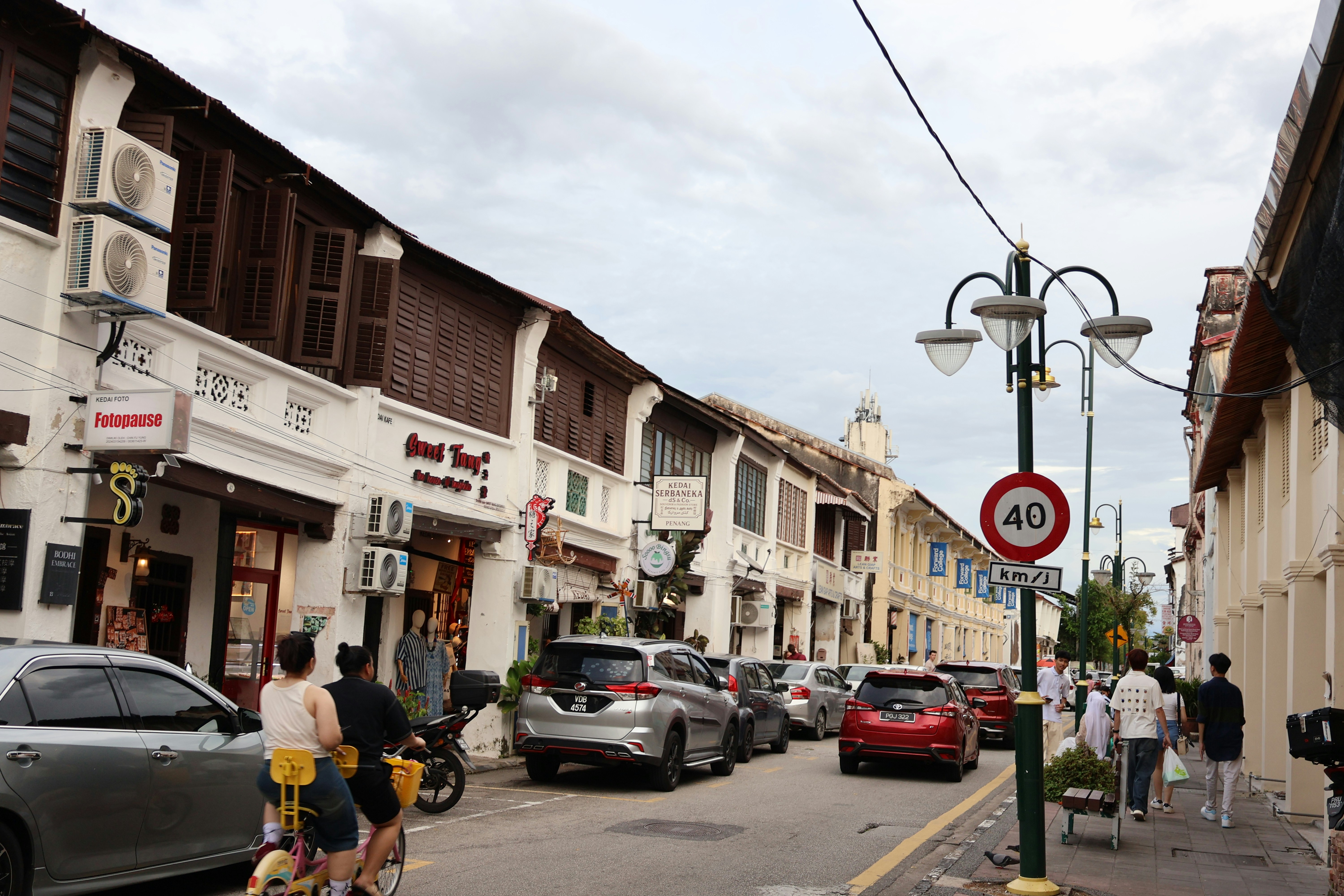 Street with old buildings and cars on a cloudy day.
