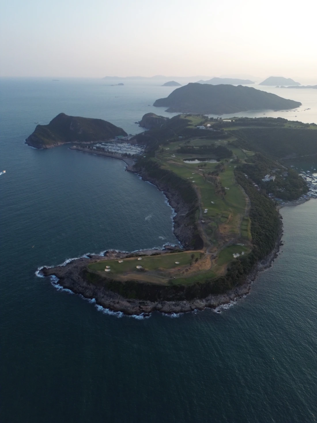 Aerial view of a dramatic coastal golf course on a clifftop peninsula