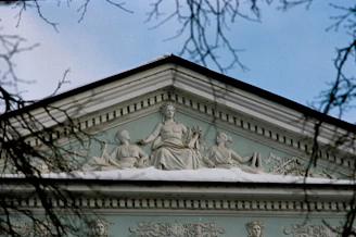 Architectural facade with classical sculptures under blue sky