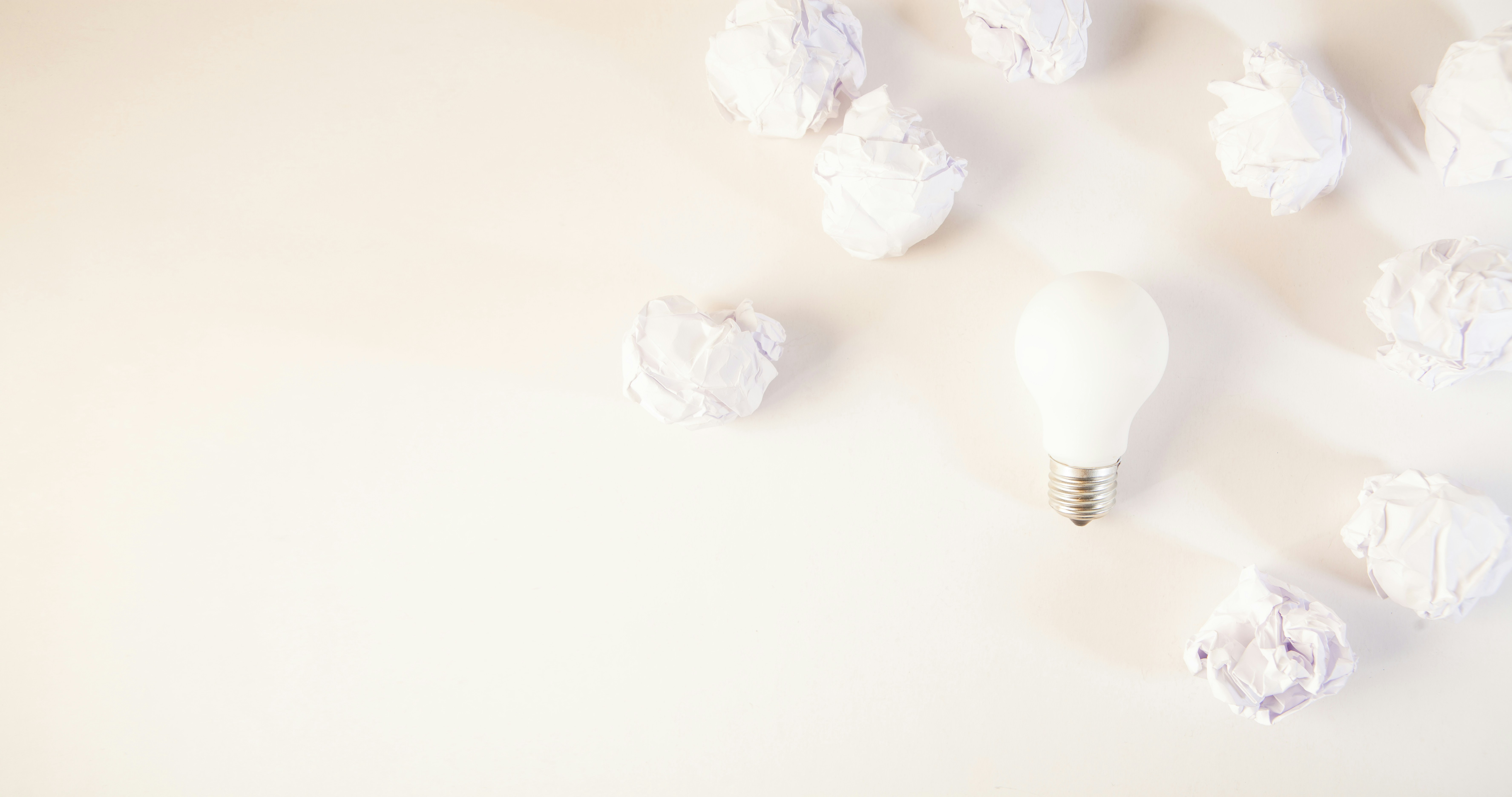 Light bulb surrounded by crumpled paper balls.