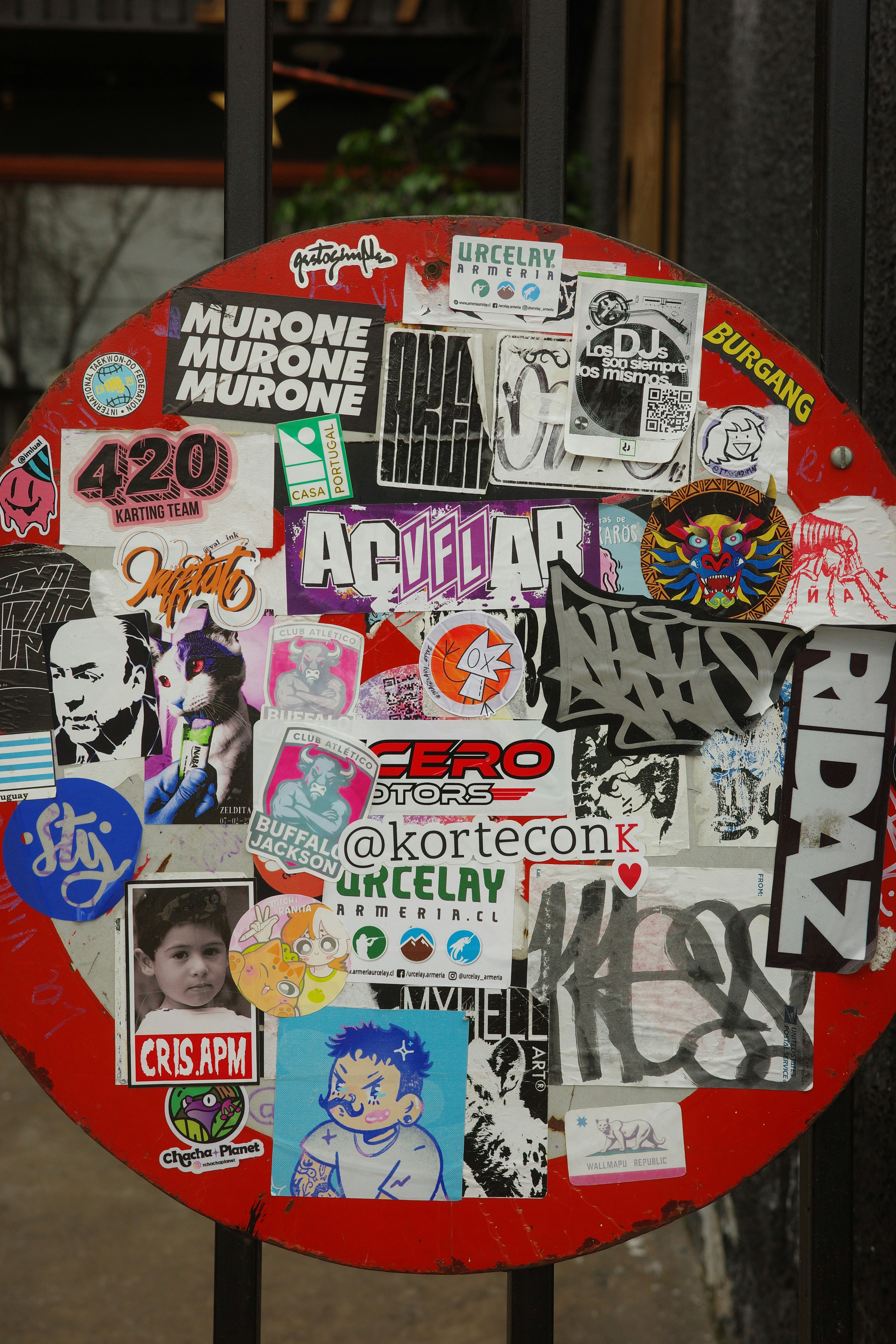 赤い円形の看板は様々なステッカーや落書きで覆われています。