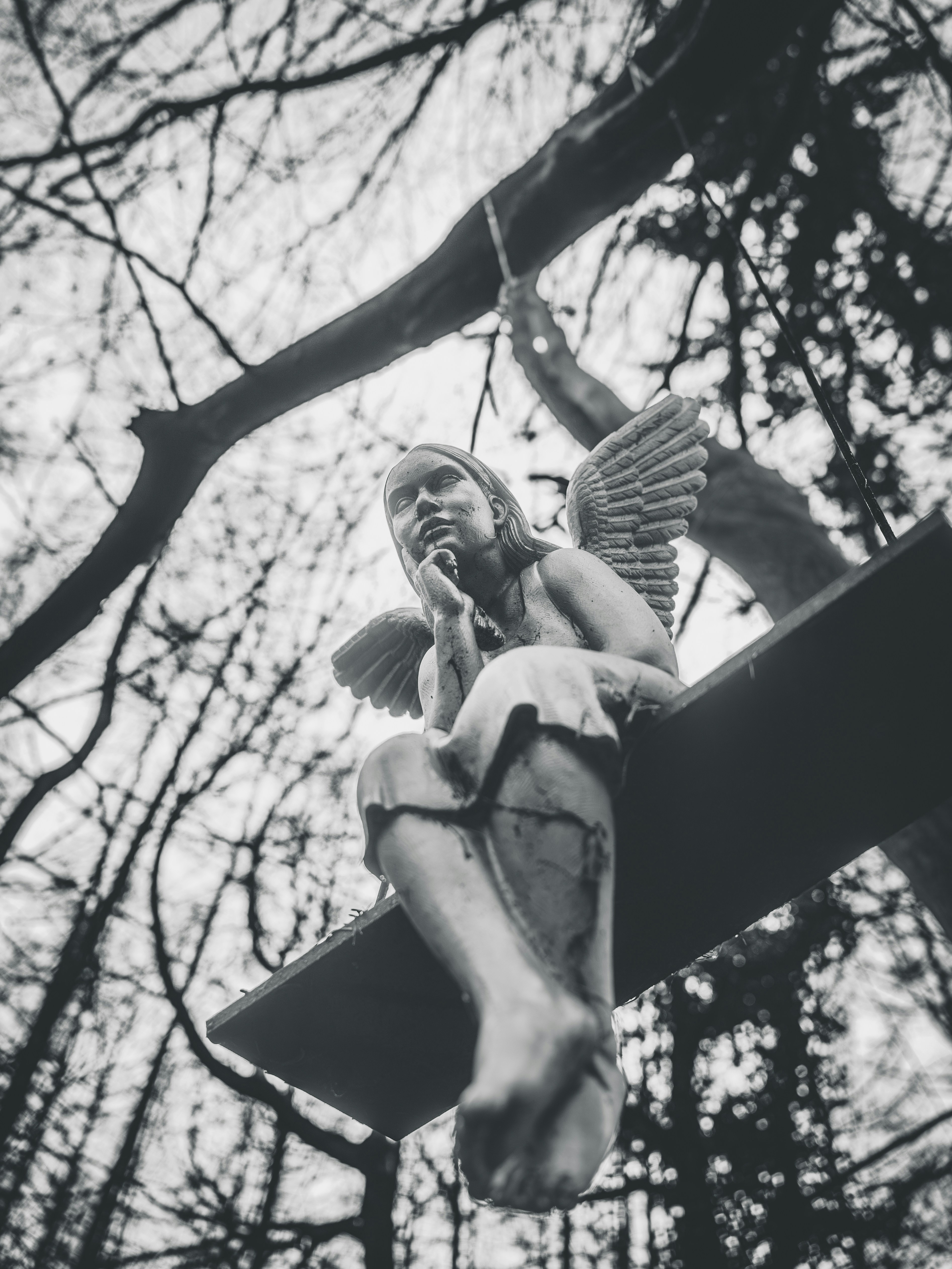 Angel statue sitting on a wooden plank