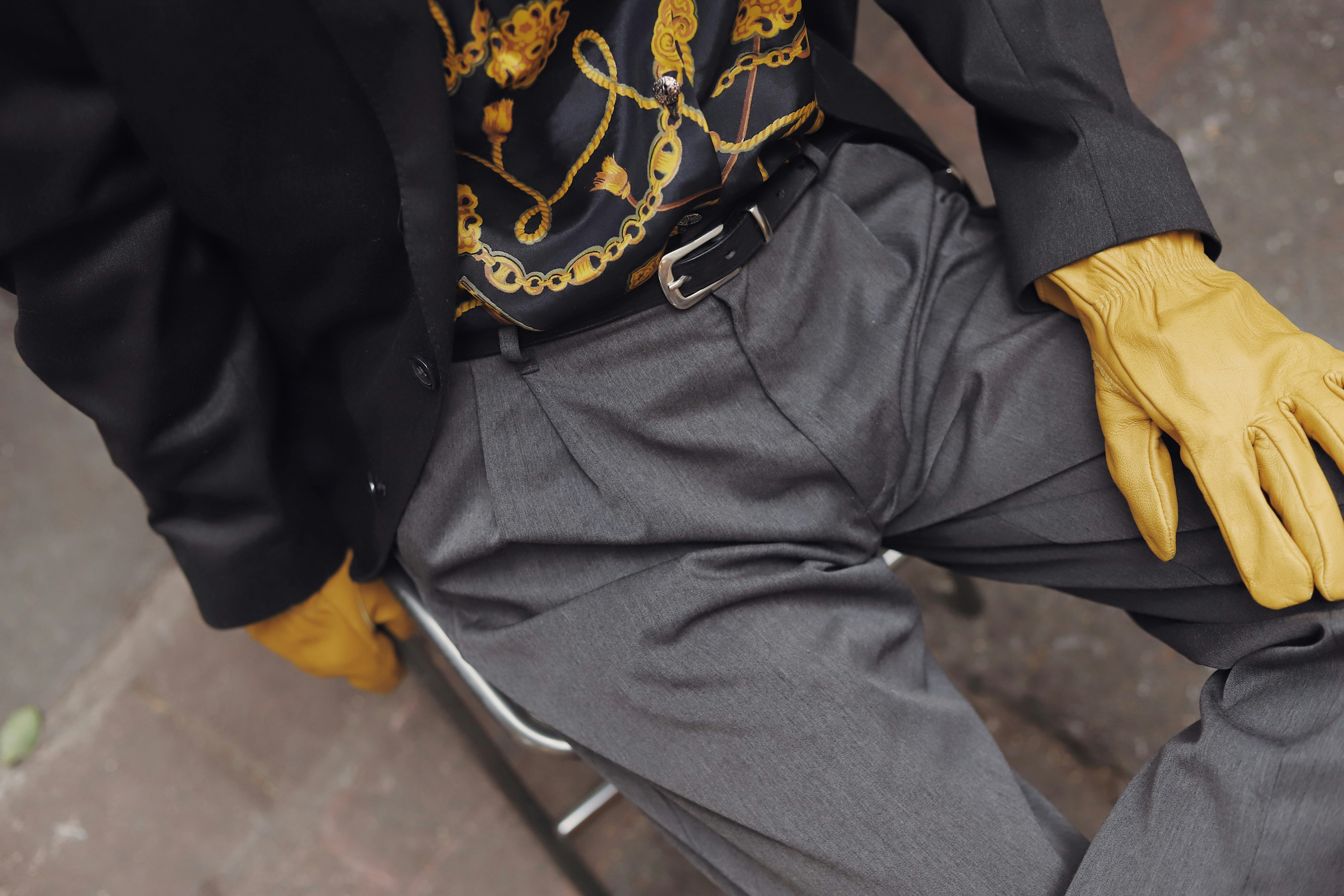 Man in suit with yellow gloves sitting down