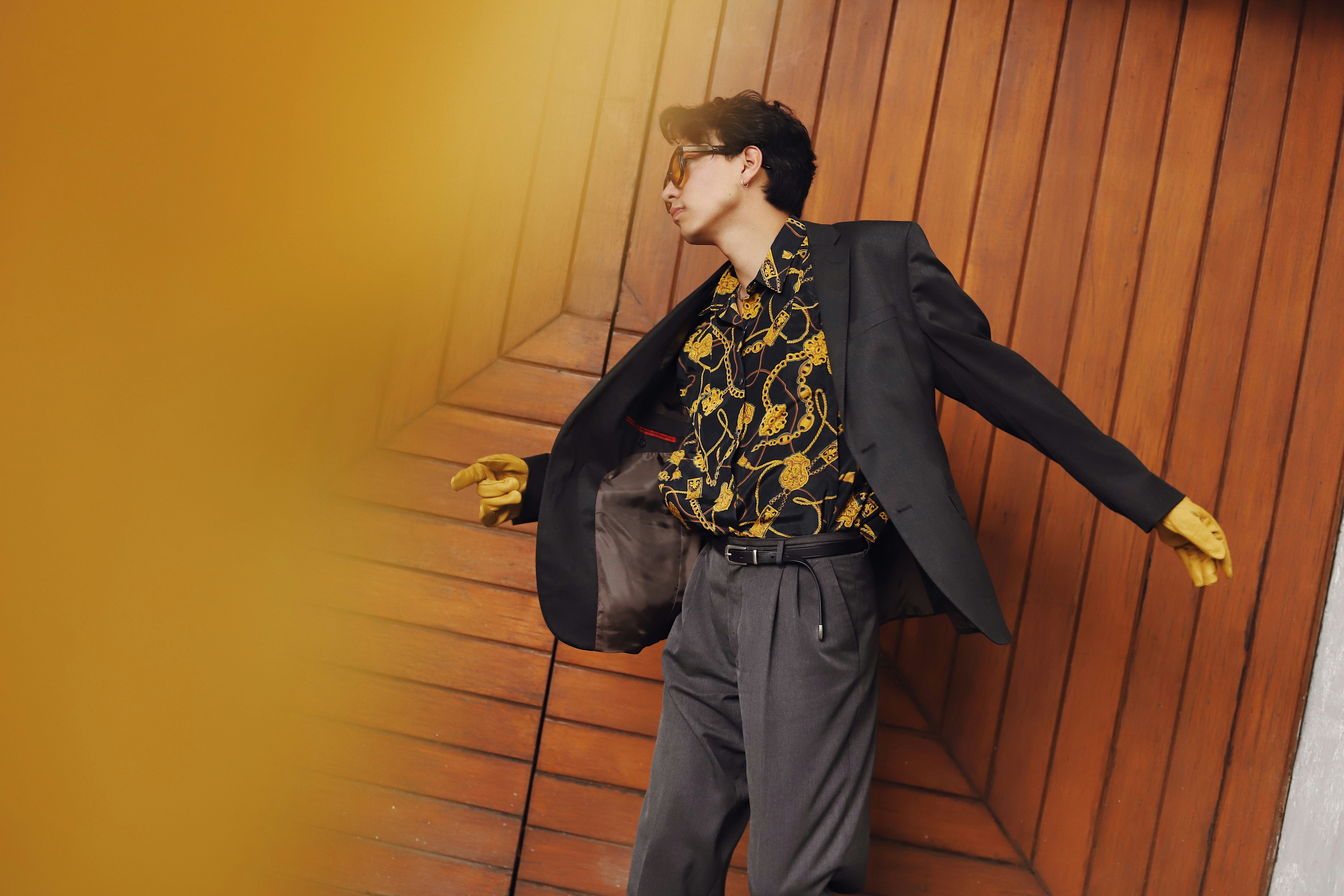 Man in suit with patterned shirt and gloves