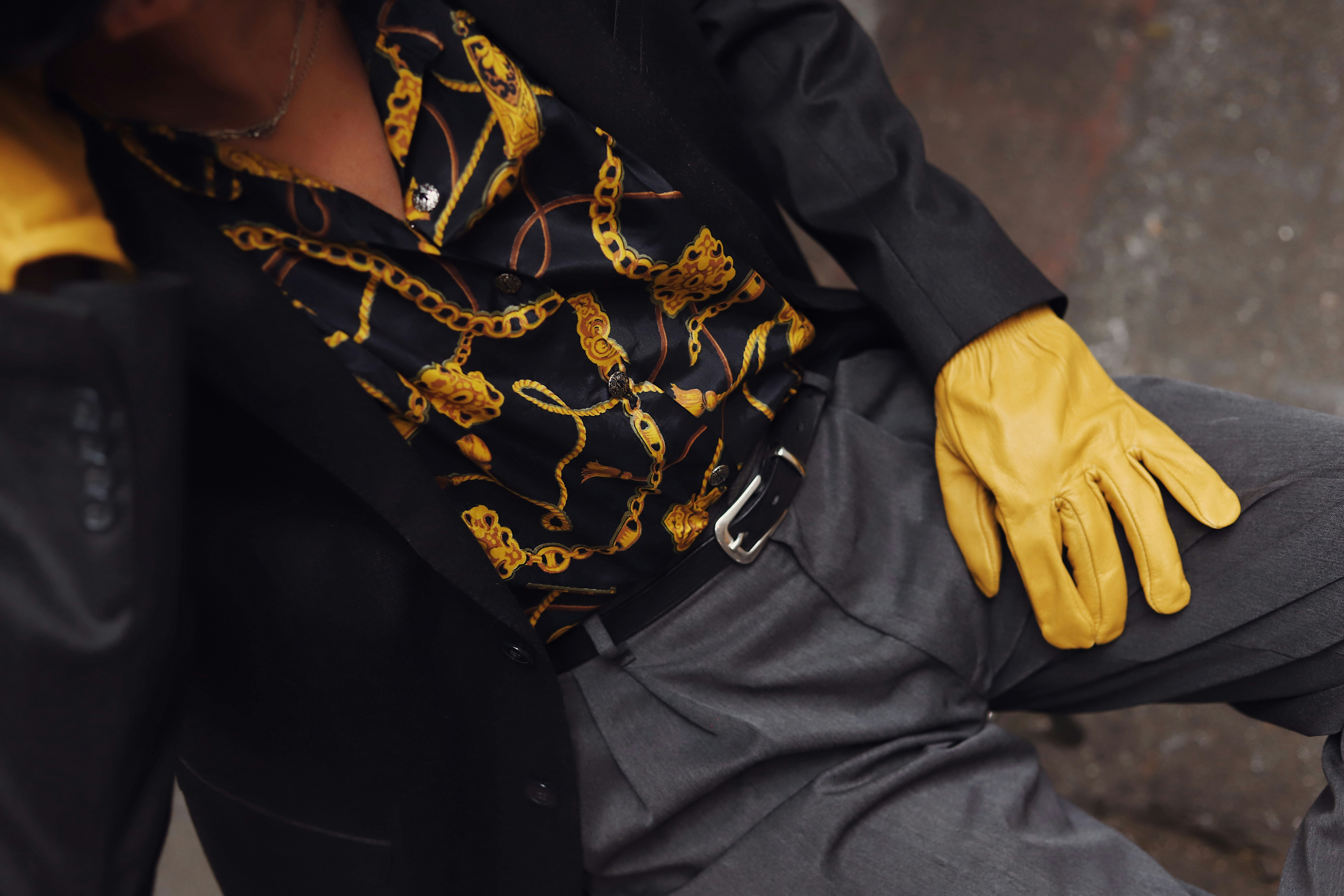 Man in patterned shirt and yellow gloves rests