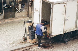 Man loading boxes from a truck onto a dolly.