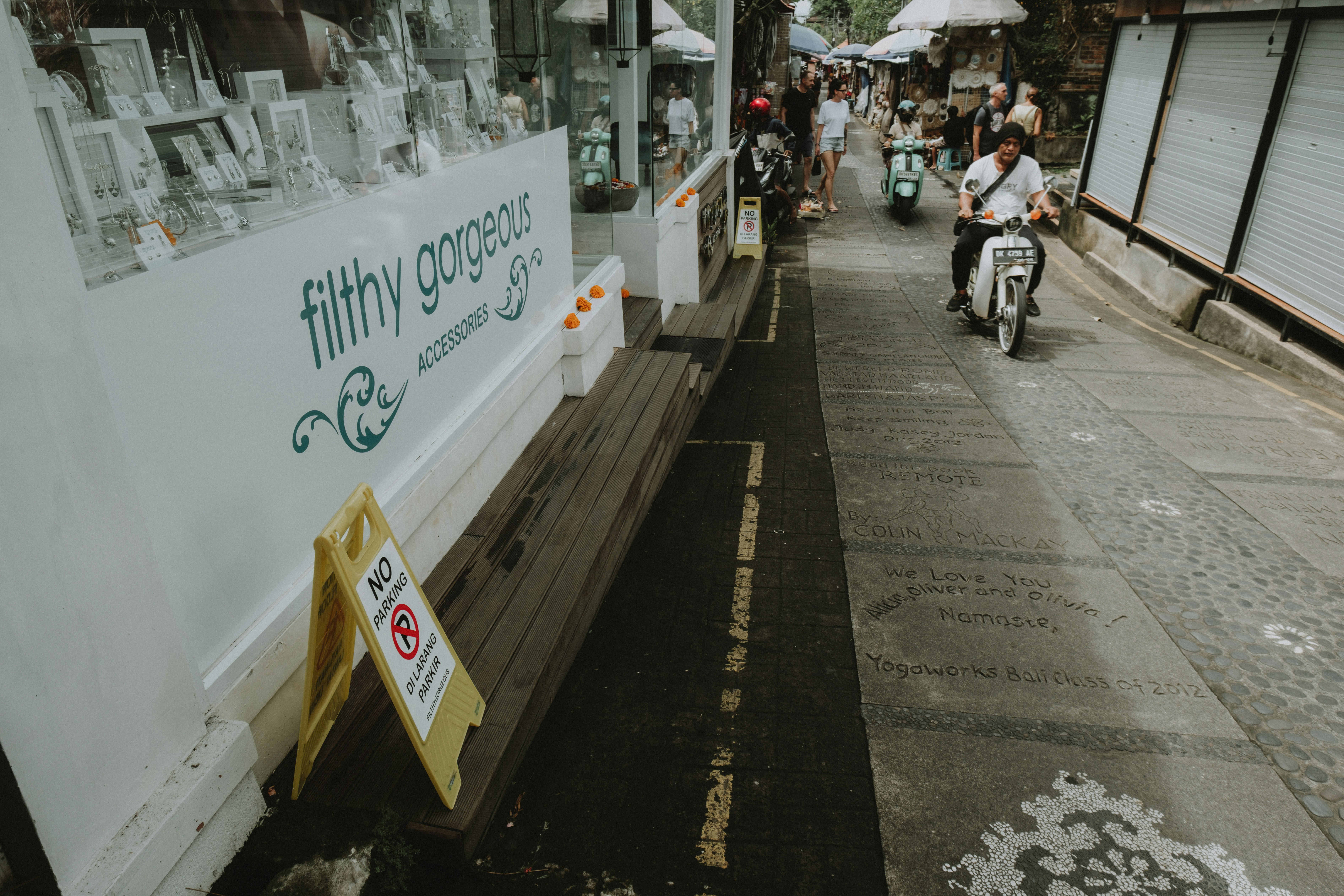 A street scene with a store window and scooters.