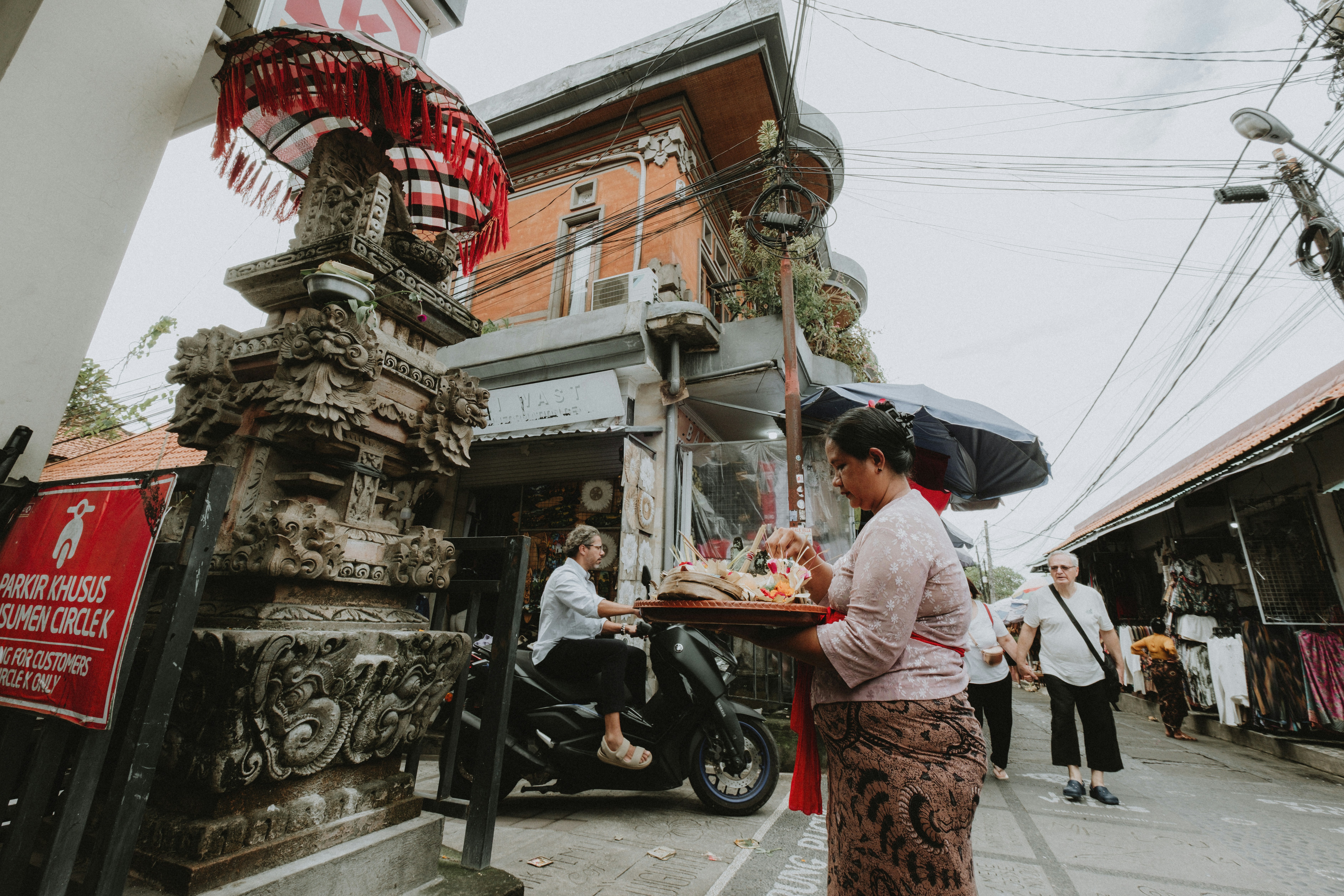 Person carrying offerings near a temple entrance in Bali
