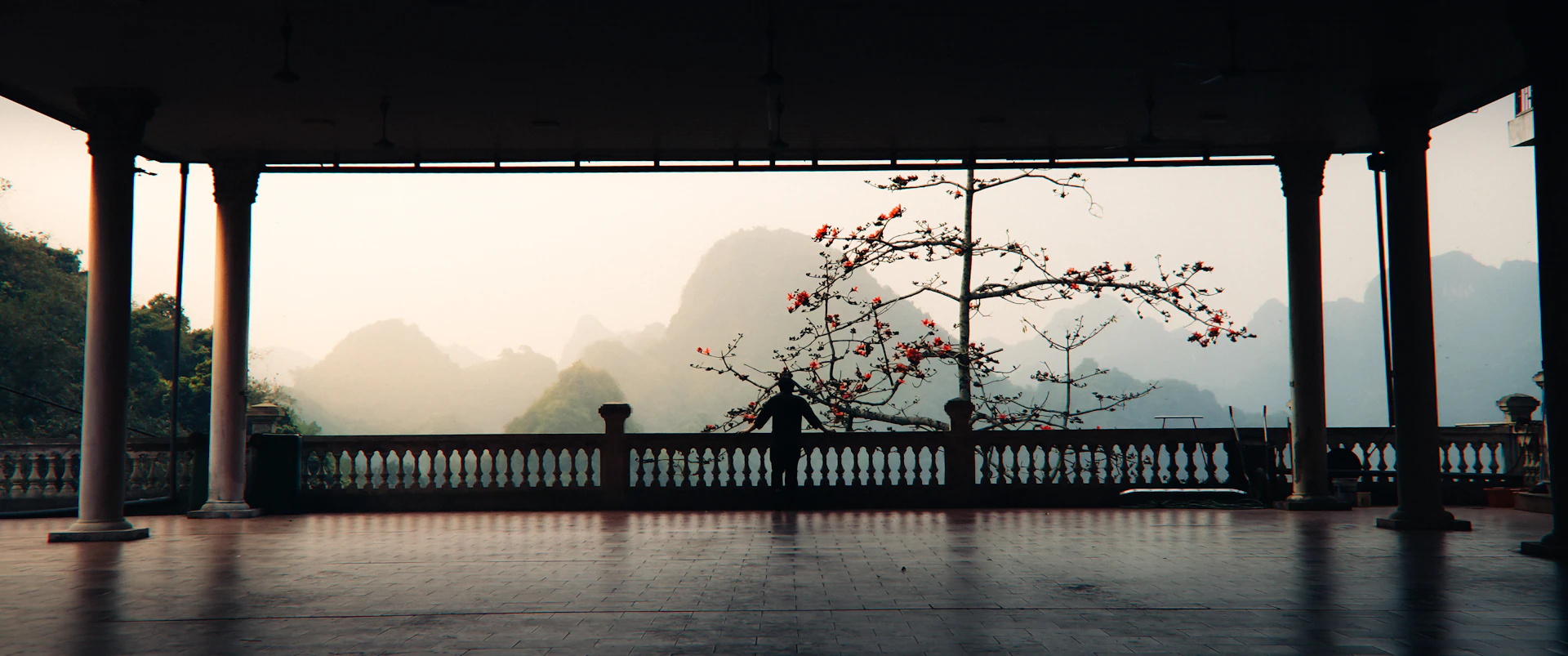 Open-air yoga pavilion overlooking misty mountains