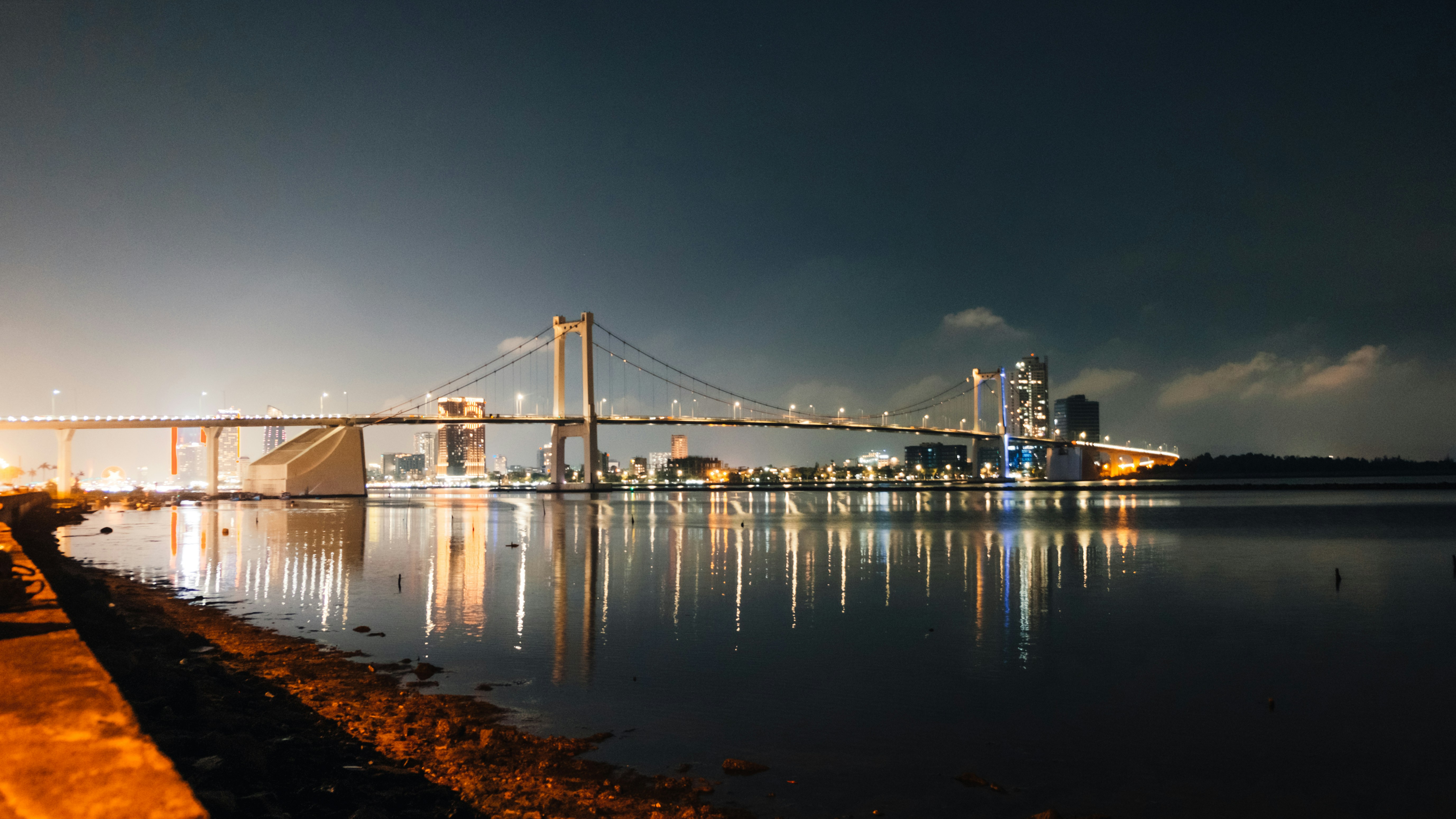 밤에 물 위에 밝게 빛나는 현수교