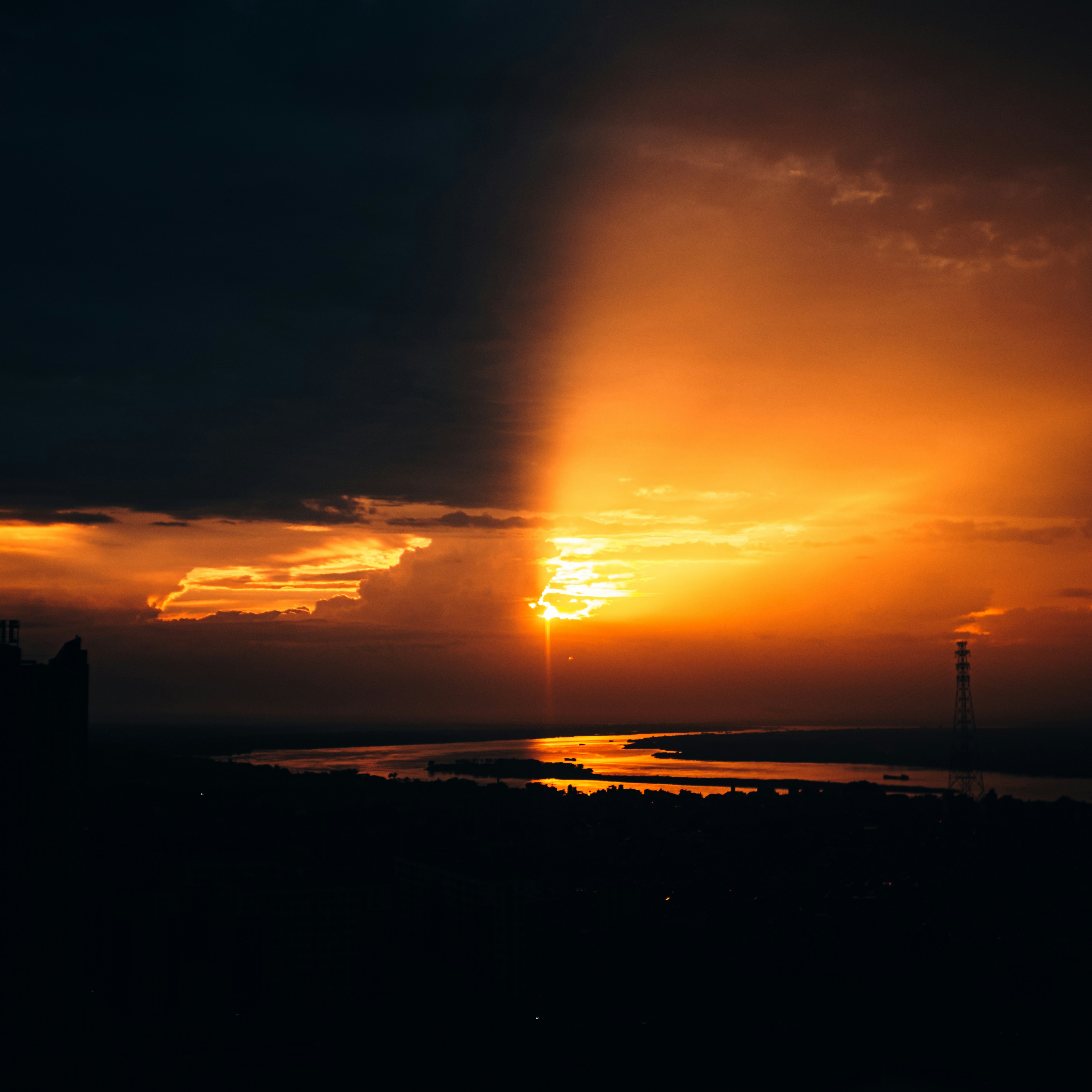 어두운 풍경 위에 햇살이 비치는 극적인 일몰.