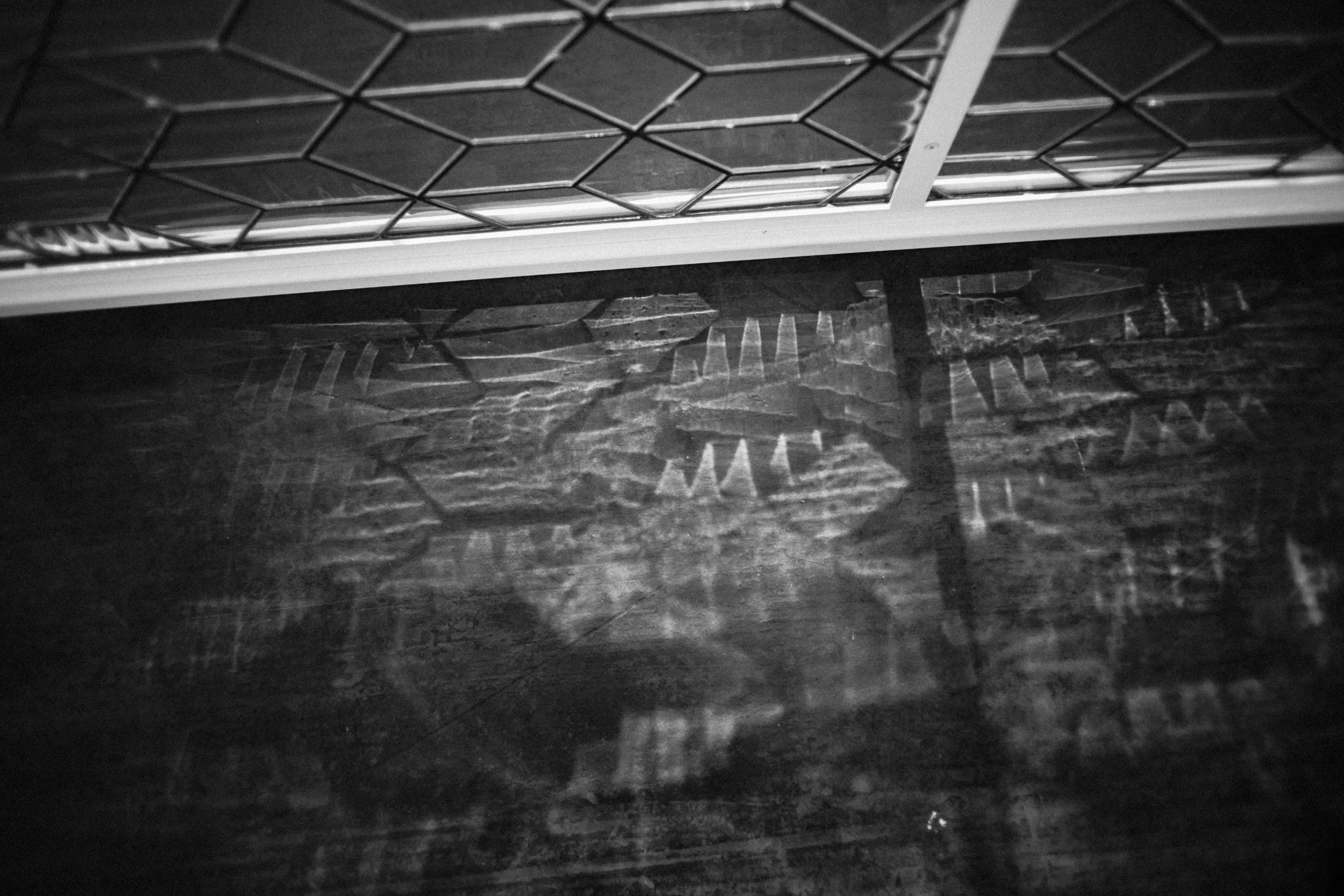 Abstract geometric patterns reflected on a dark surface.