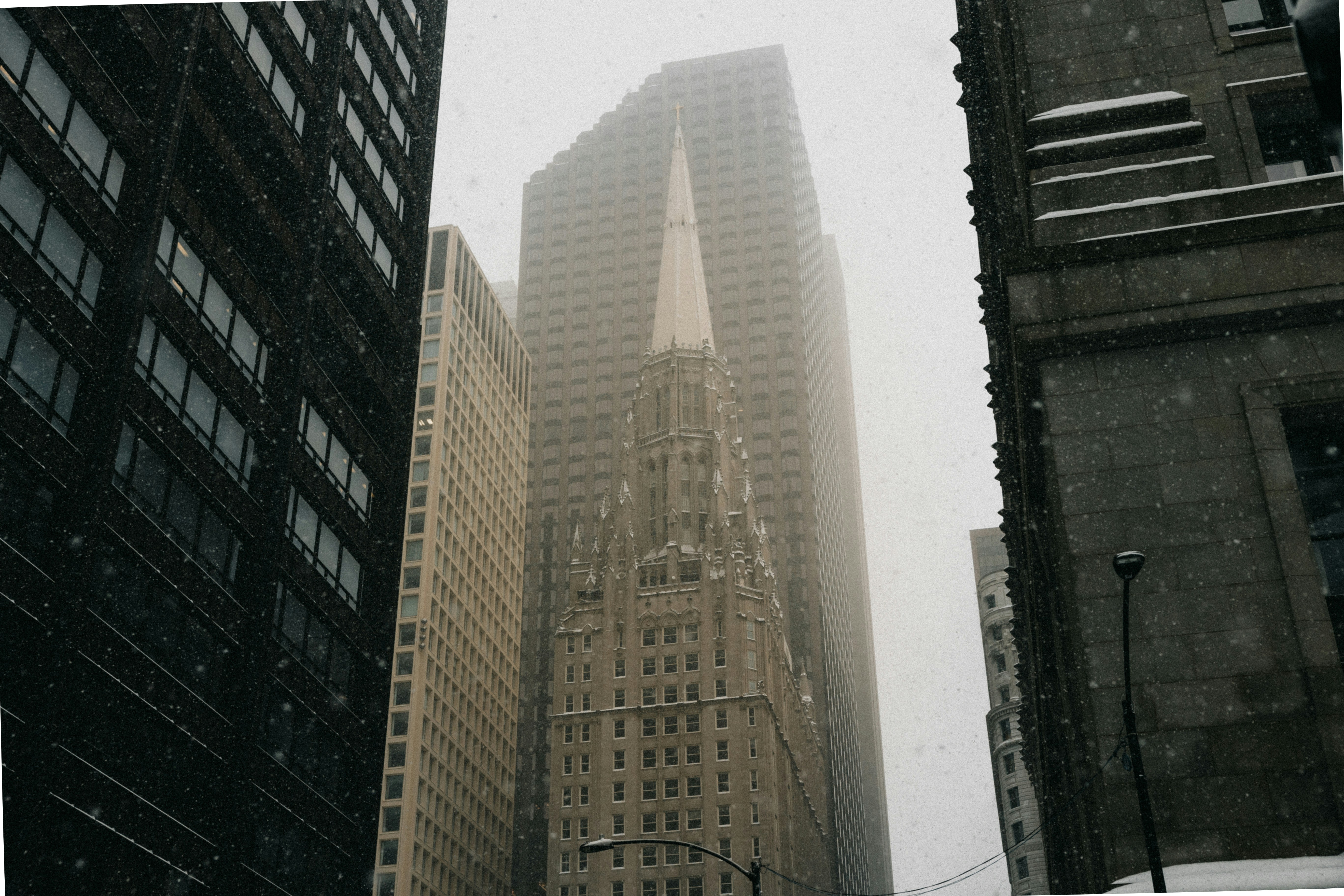 Tall buildings in a foggy city with snow