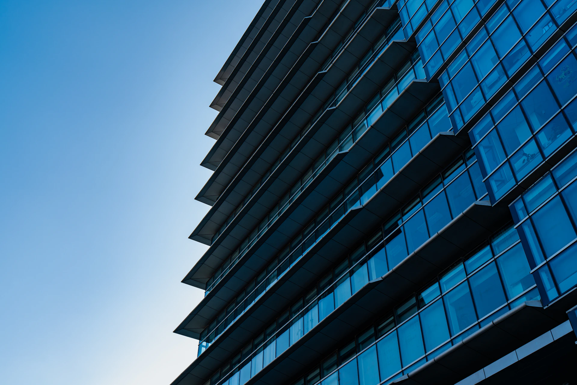 Modern skyscraper with blue glass windows against sky