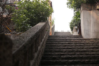Stone stairs ascend towards a bright, hazy sky.
