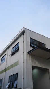 Modern industrial building with large windows and clear sky